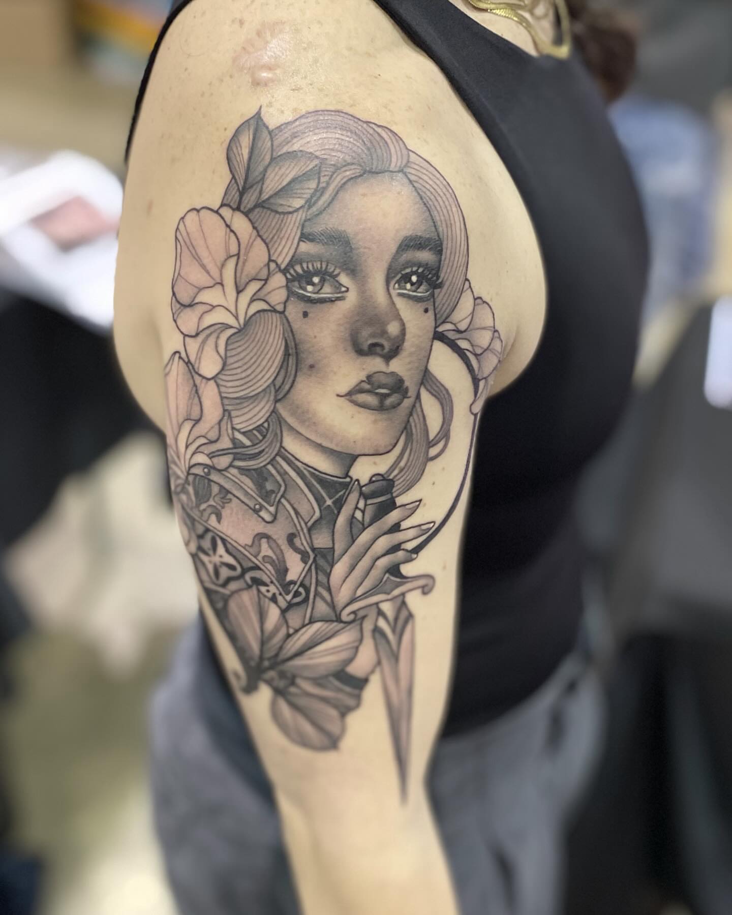 Woman with flowers realism tattoo on the upper arm by Connie Fiorino - Tattoo Artist