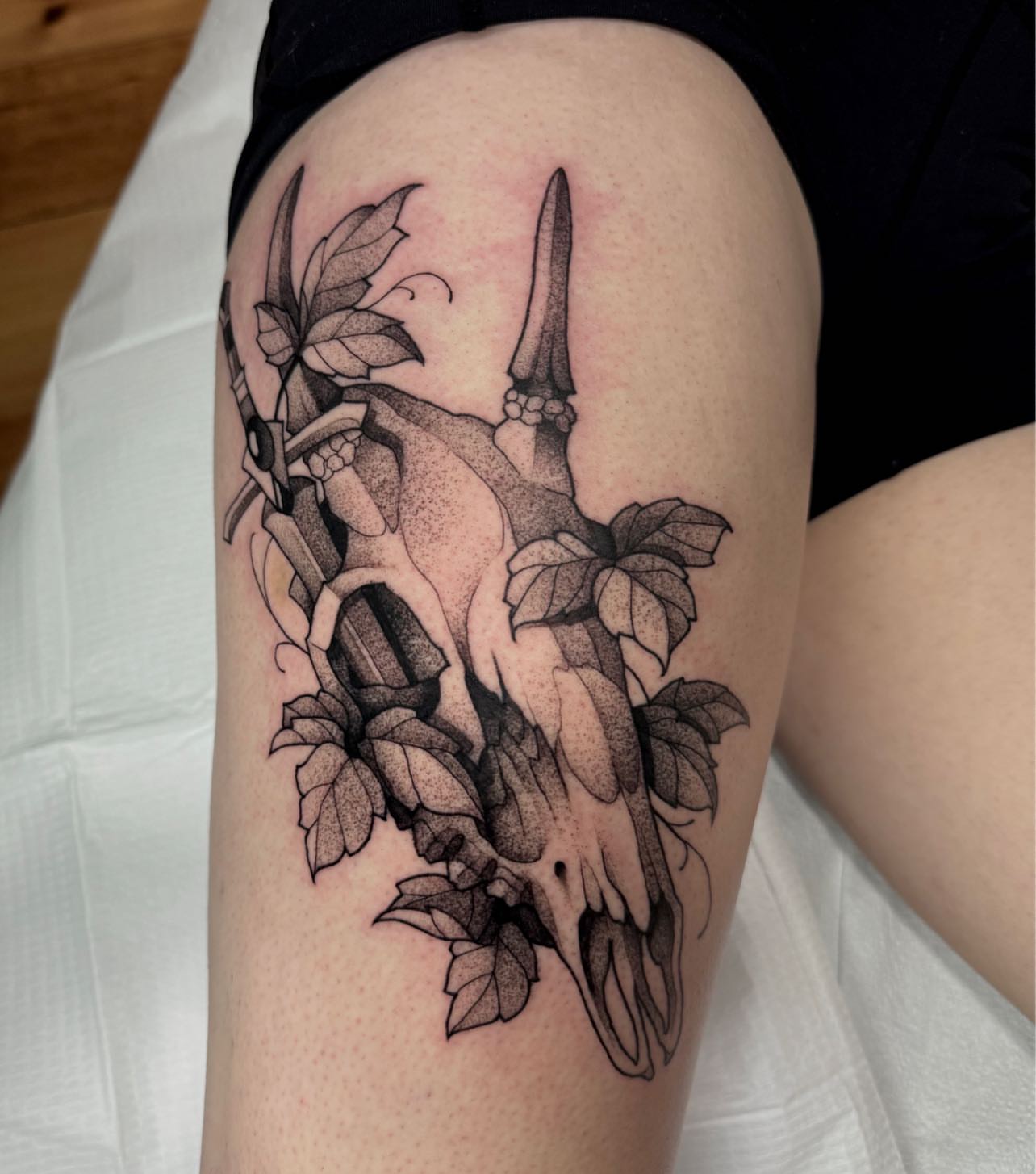 Skull and ivy dotwork tattoo on the thigh by Lauren Peltz