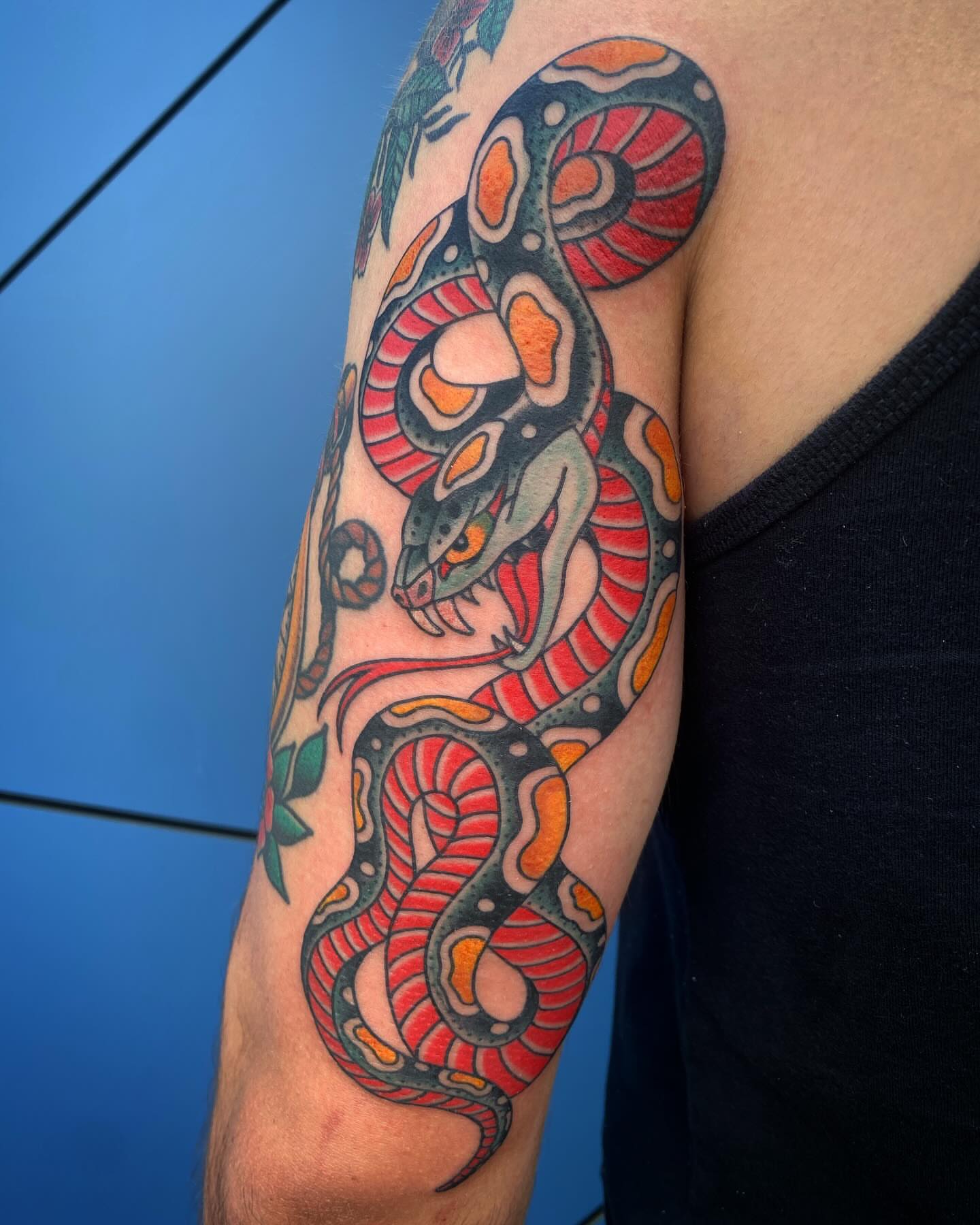 Snake American traditional tattoo on the upper arm by Adam Warmerdam, Los Angeles, California
