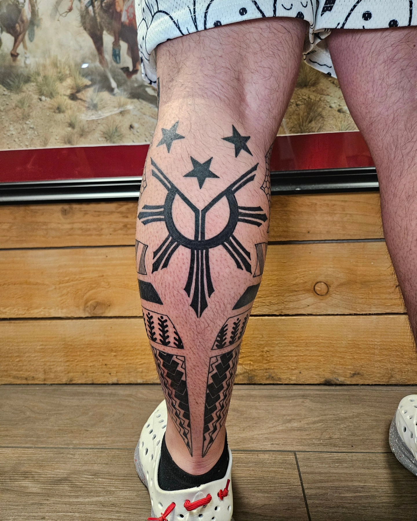Filipino sun and stars black and grey tattoo on the calf by Nicole Bett