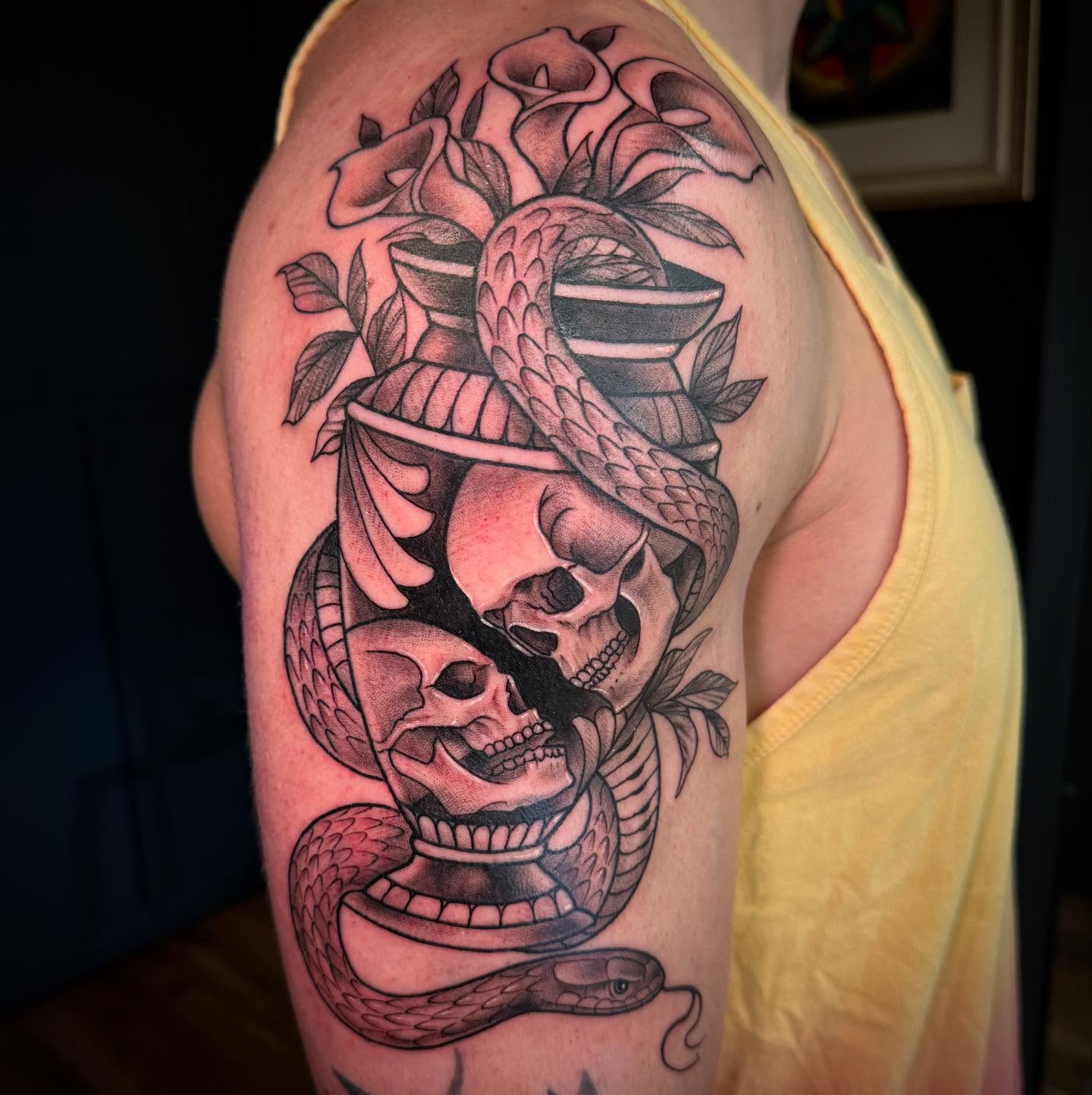 Snake and skulls realism tattoo on the shoulder by Brad Sterling