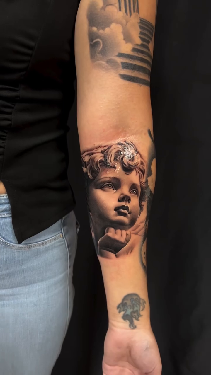 Cherub face realism tattoo by Thomas Conard