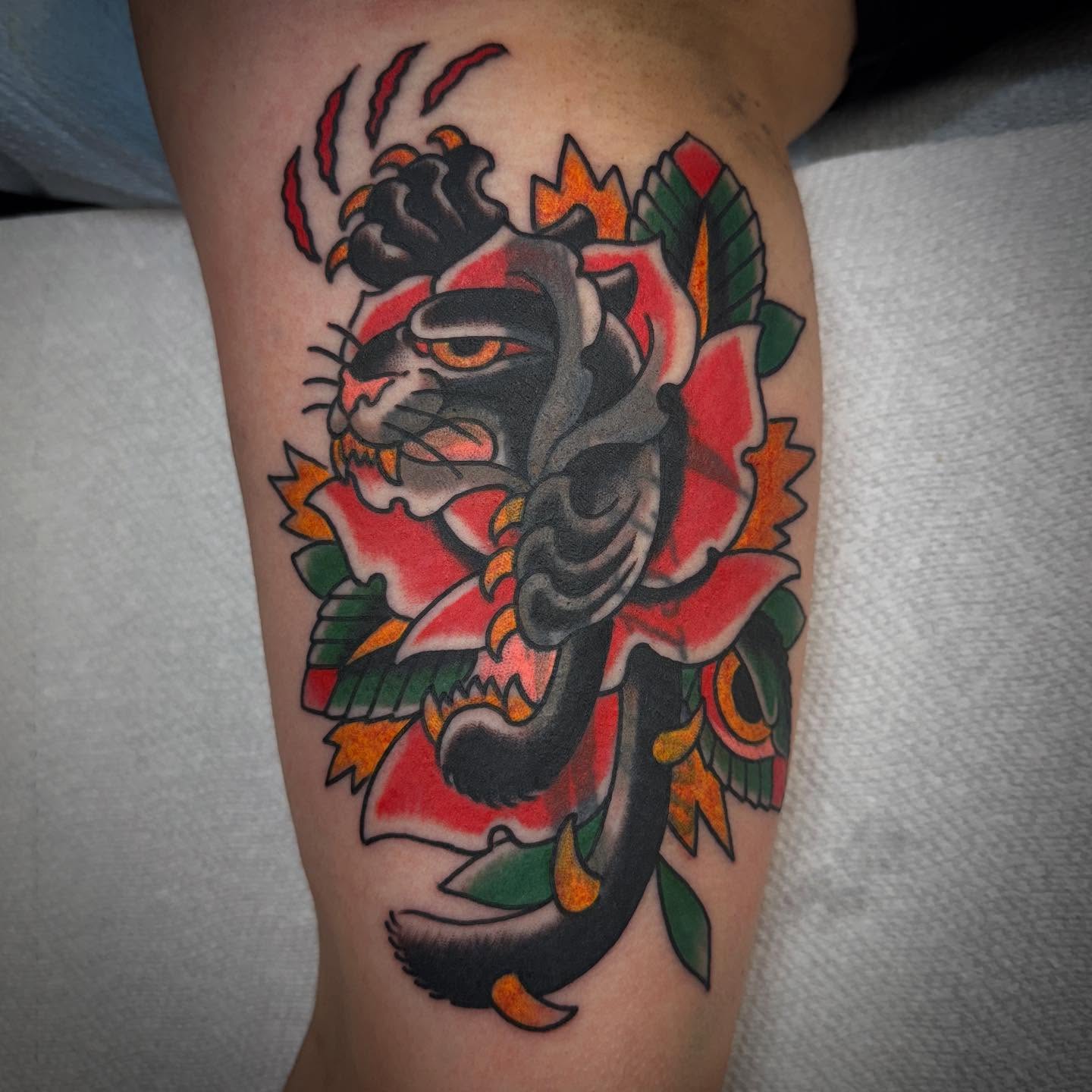 Tiger and floral American traditional tattoo on the forearm by Ethan Bennett