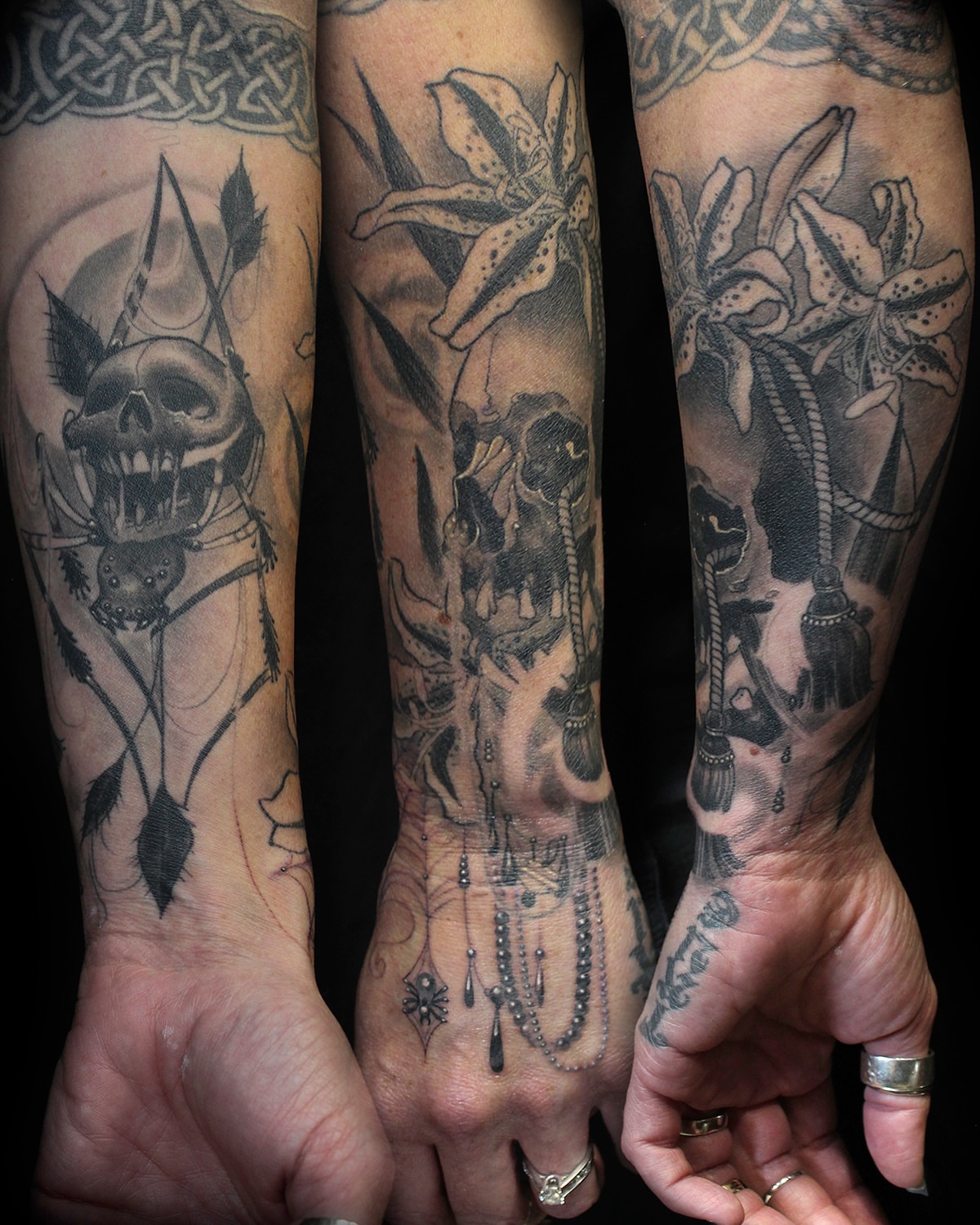 Lilies and skull realism tattoo on the forearm by Ella Trick