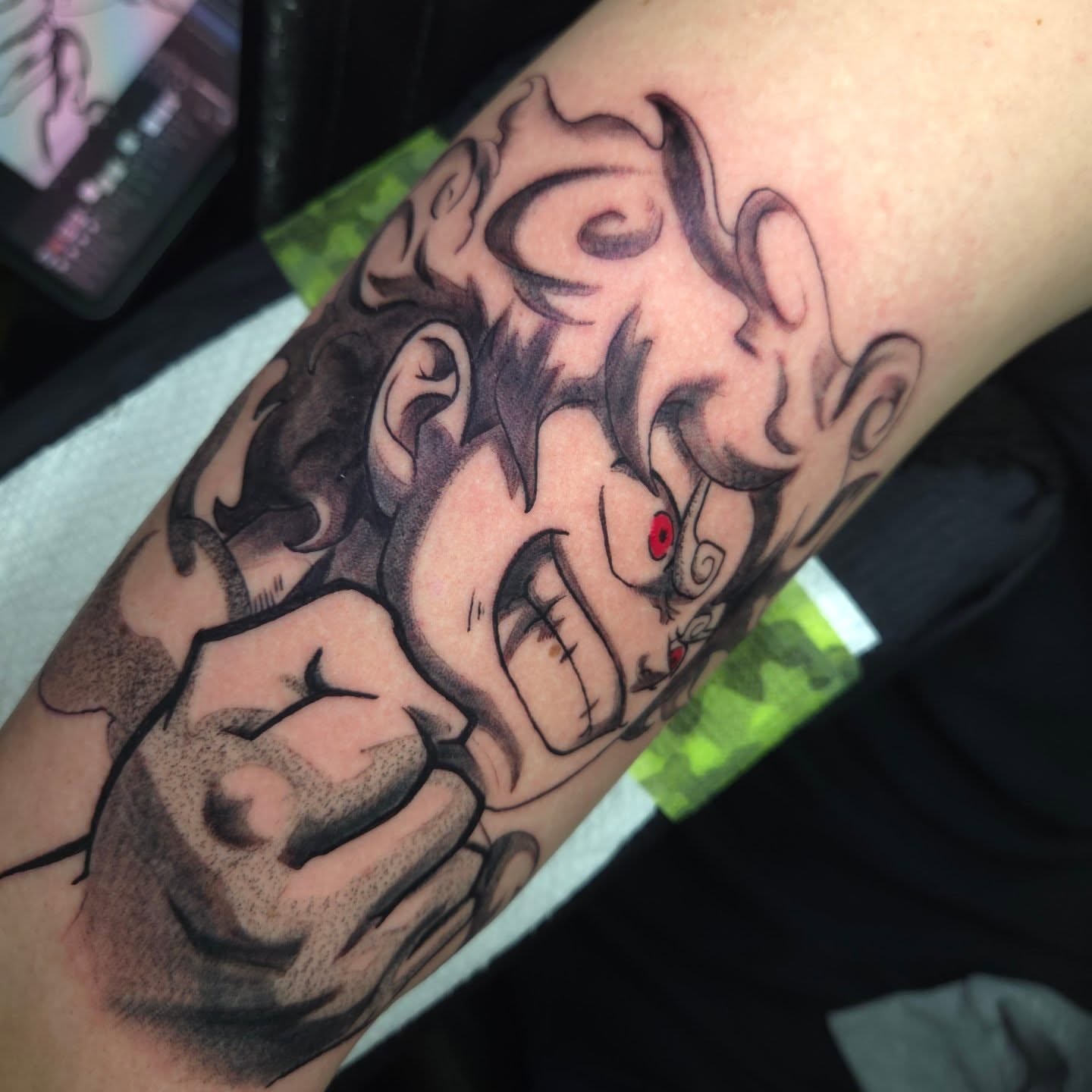 Angry clown black and grey tattoo on the forearm by Nic Mann
