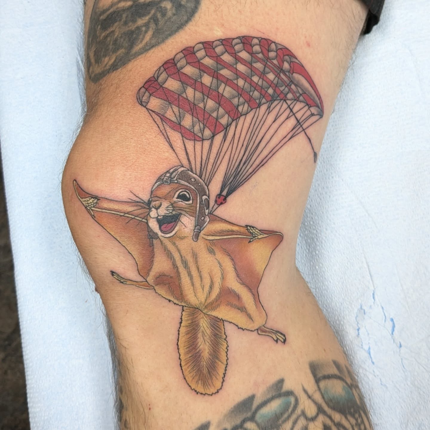 Parachuting squirrel realism tattoo on the forearm by Kara Falcon