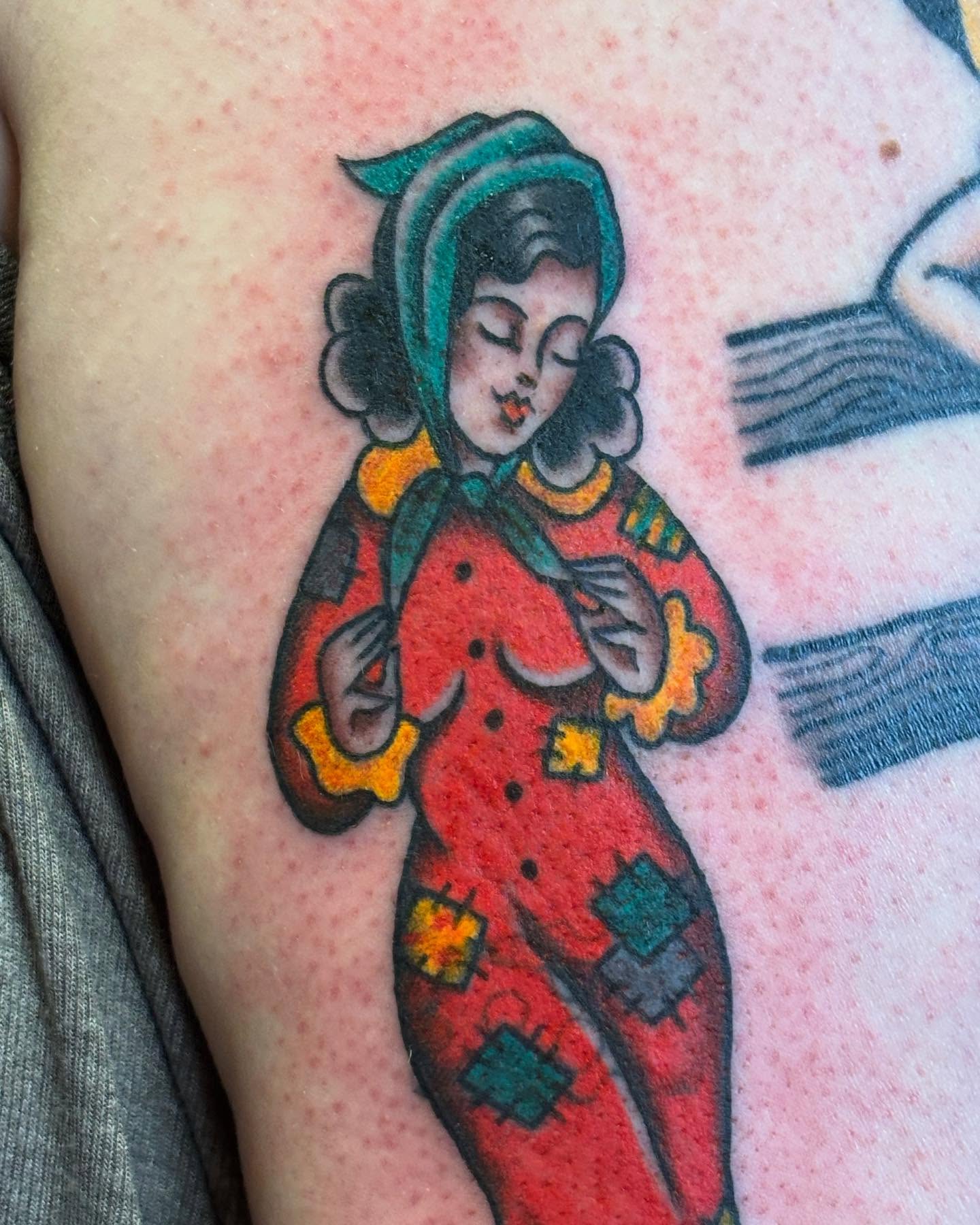 Woman in vintage outfit American traditional tattoo on the upper arm by Angie Isbell