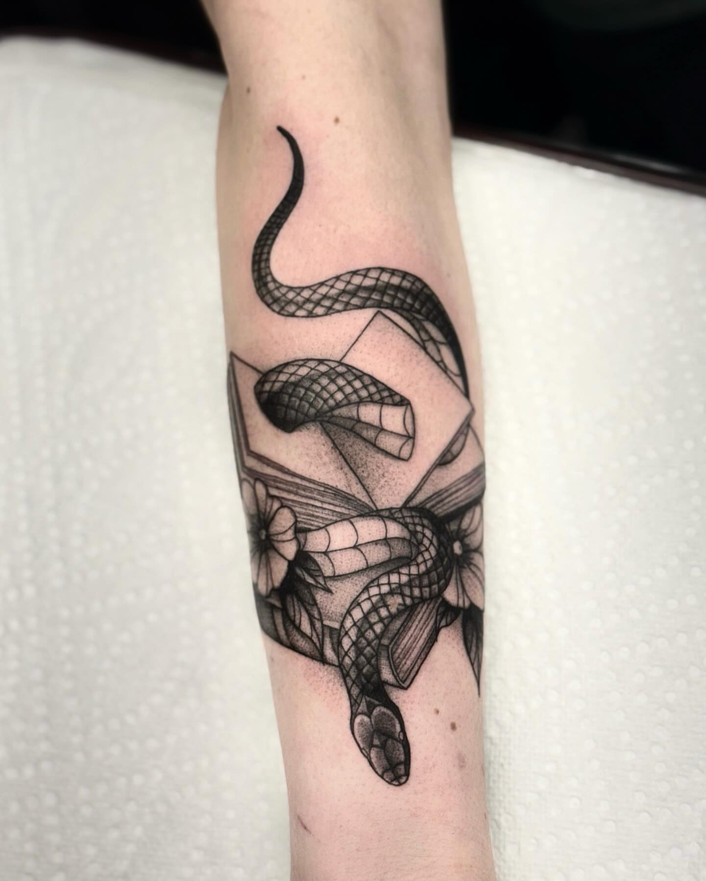 Snake and butterfly geometric tattoo on the forearm by jada