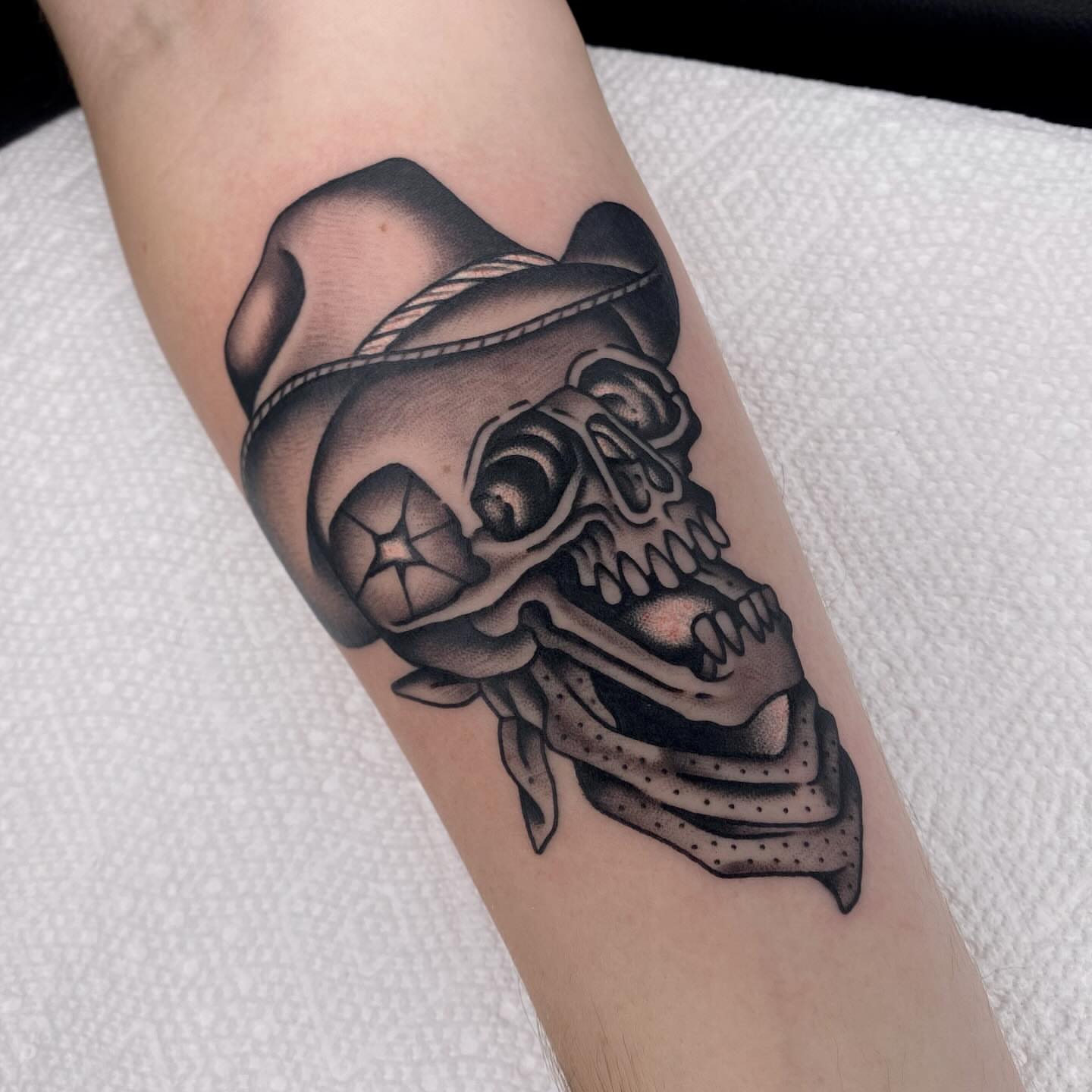 Skull wearing hat black and grey tattoo on the forearm by Justin R. Mitchell, Fort Worth, Texas