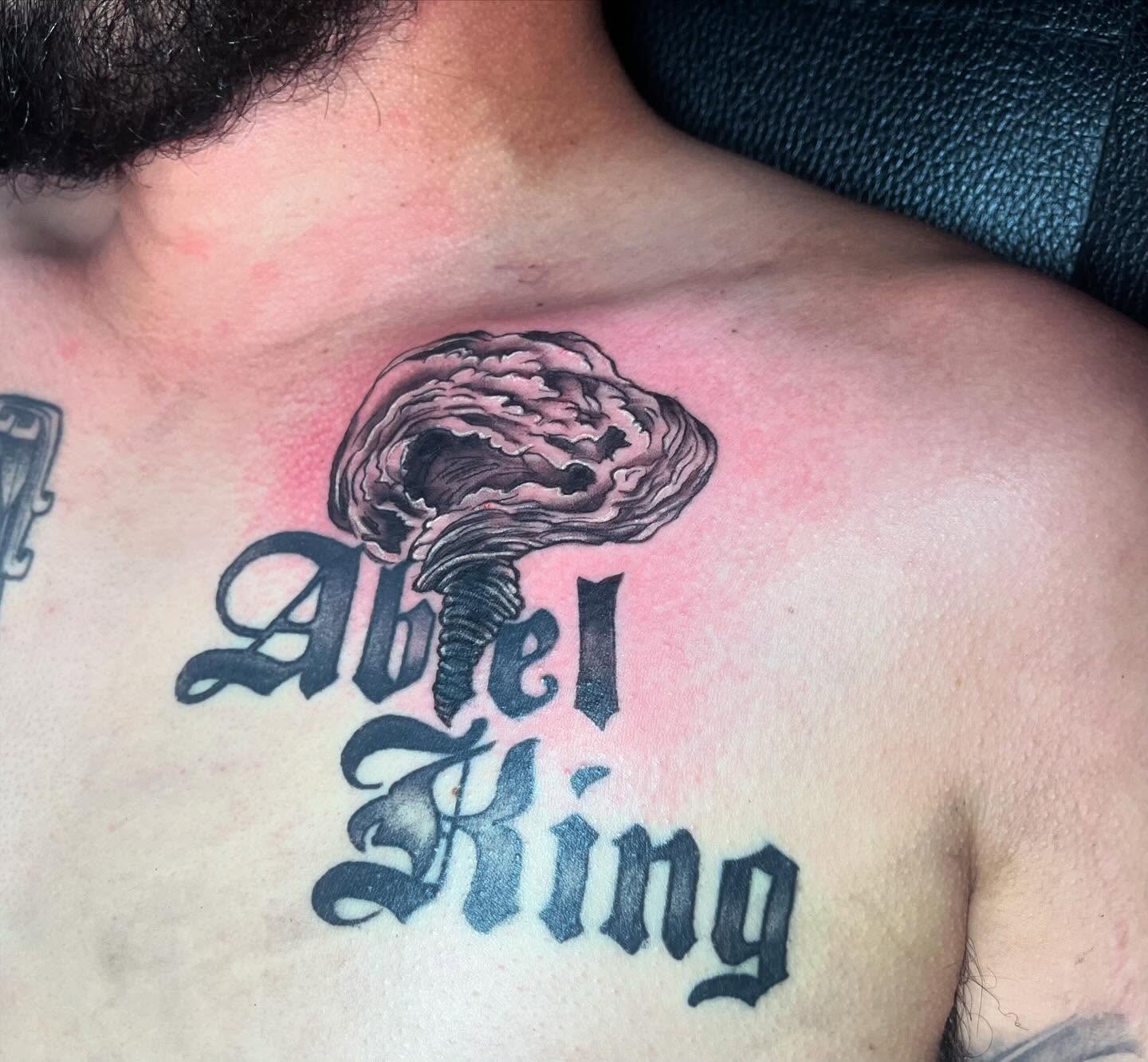 Twister and script black and grey tattoo on the chest by Ink by Hailey π