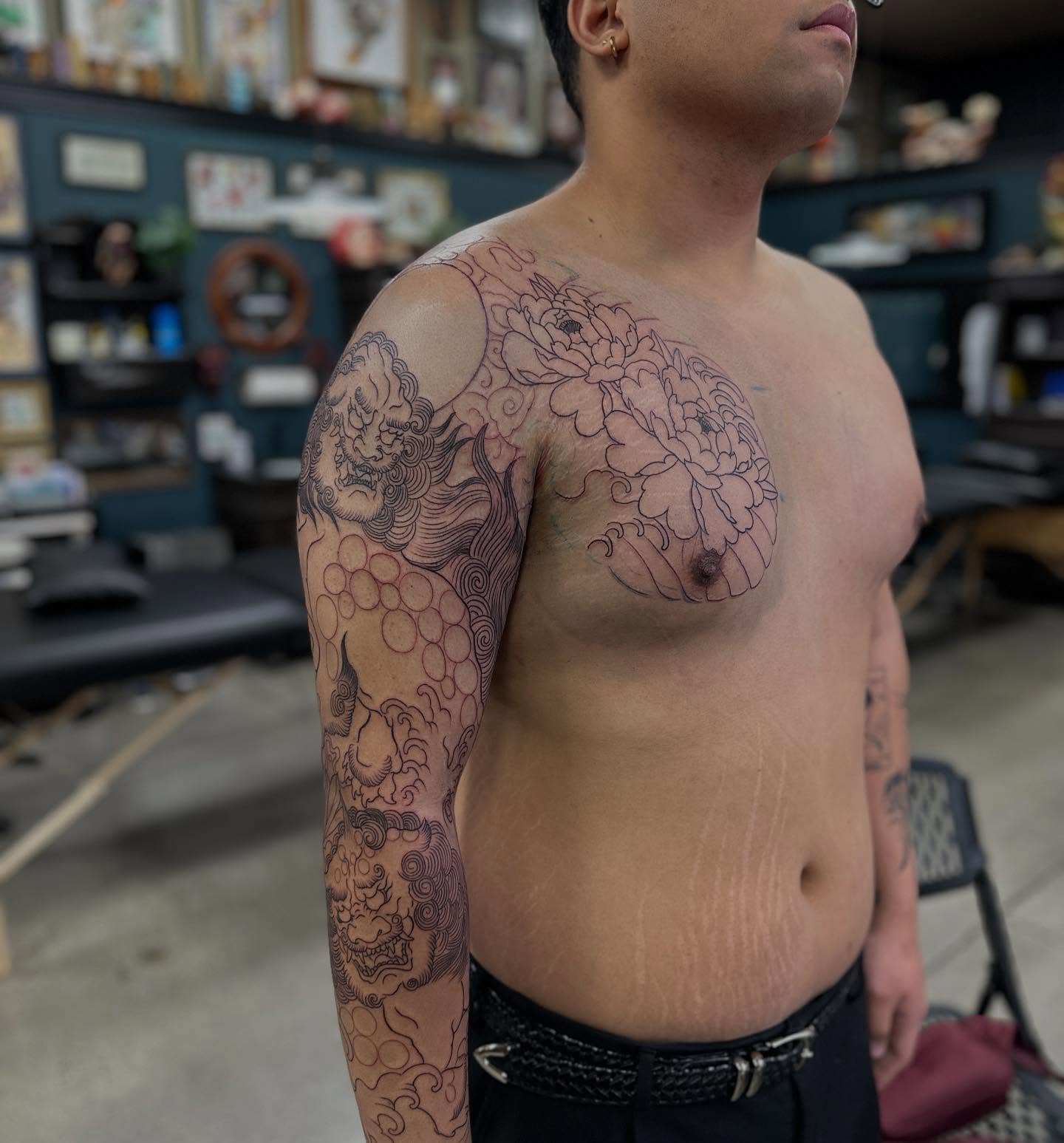 Dragon and peony black and grey tattoo on the upper arm by Shawn Feng