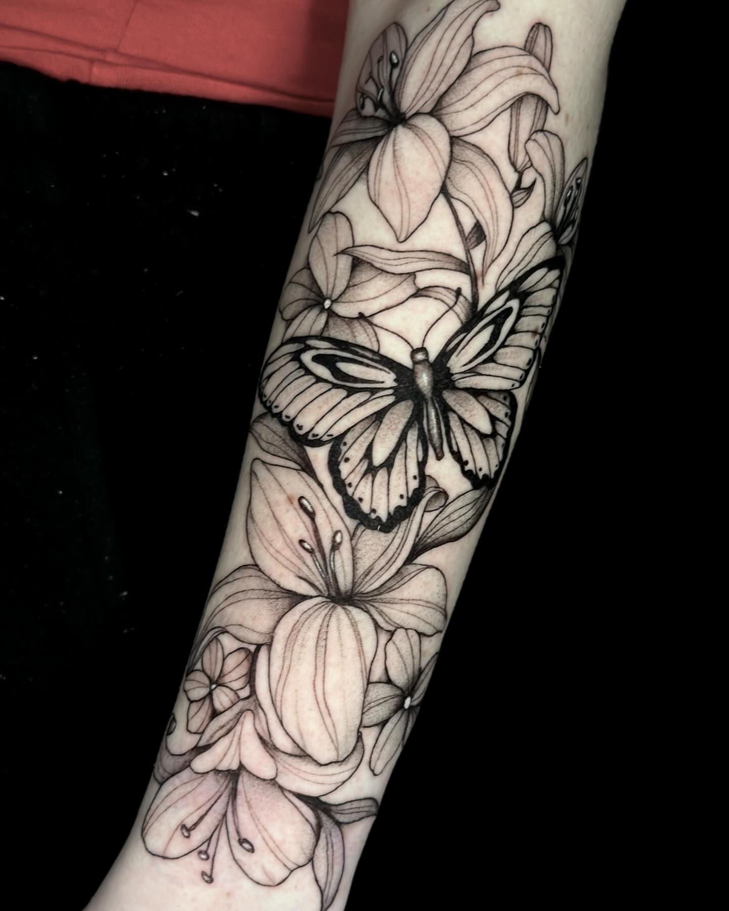 Lilies and butterfly realism tattoo on the forearm by Emmy