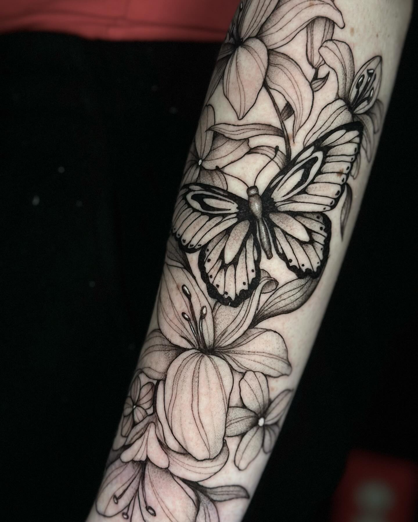 Butterfly and lilies realism tattoo on the forearm by Emmy