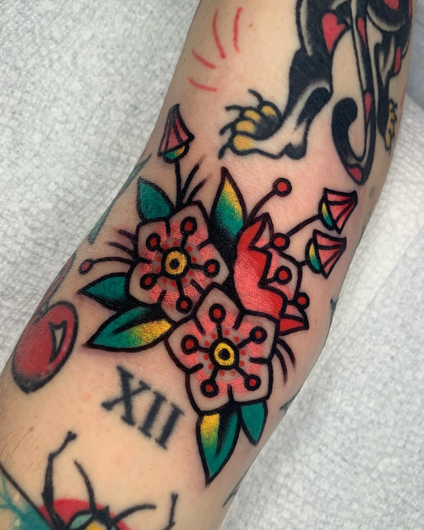 Flowers American traditional tattoo on the forearm by Shawn VanKirk