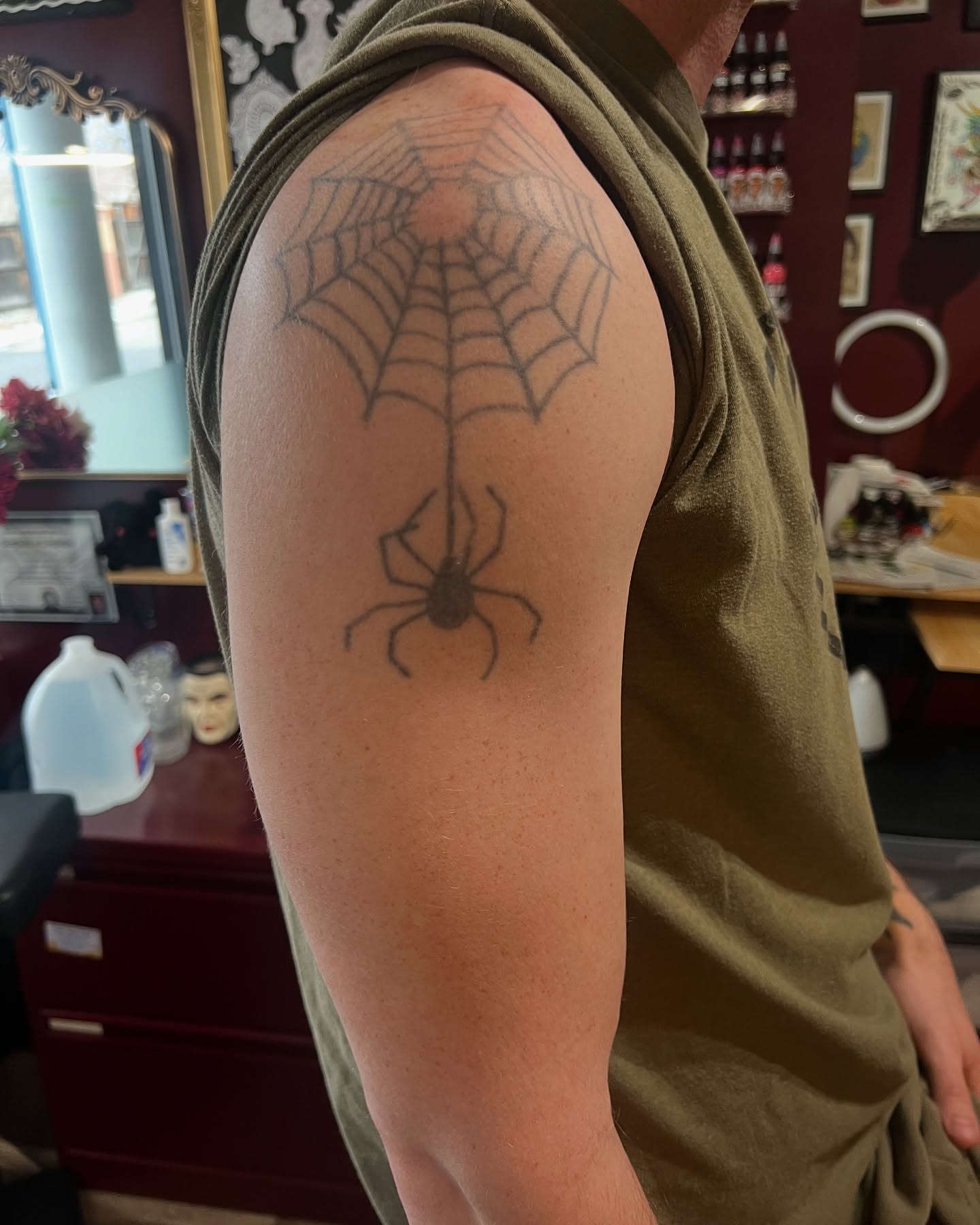 Spider web black and grey tattoo on the upper arm by Stevie Reign
