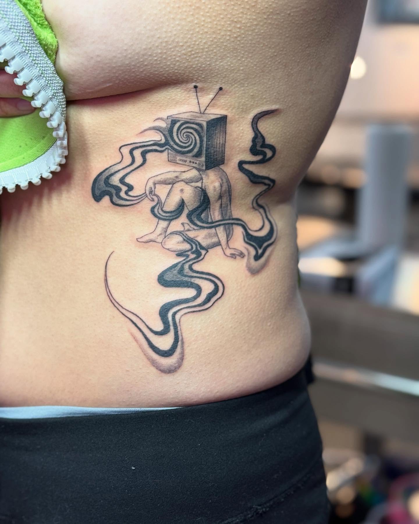 Octopus and television surrealism tattoo on the ribs by Erin Blaney