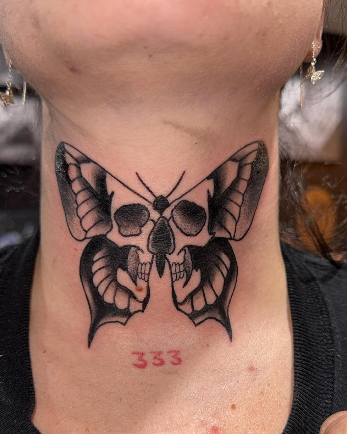 Skull butterfly black and grey tattoo on the neck by Robbie Roberson