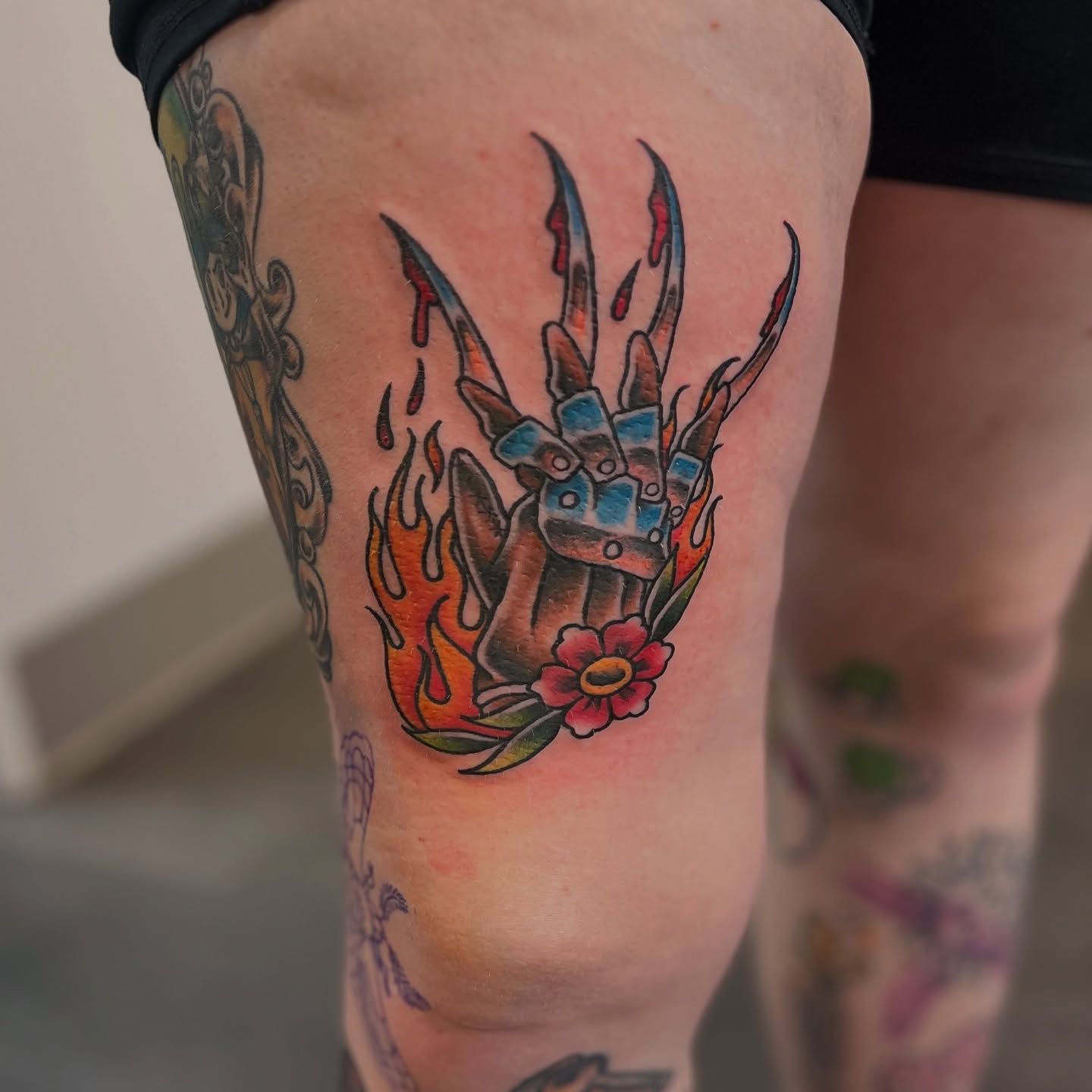 Robotic hand with flames American traditional tattoo on the thigh by Luna Faye