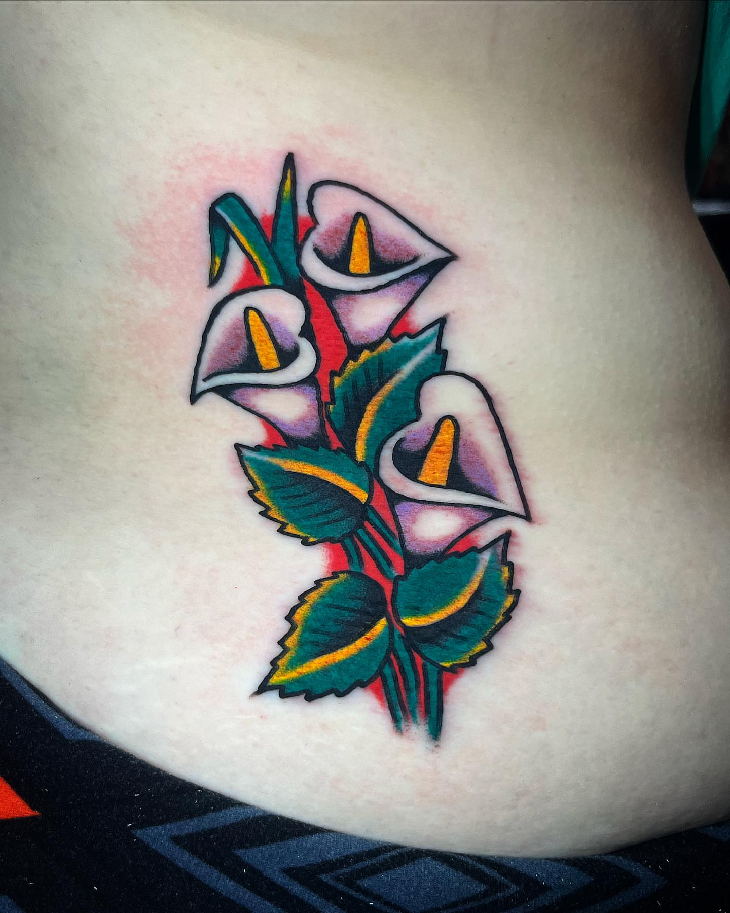 Calla lilies American traditional tattoo on the thigh by Jake LiCausi