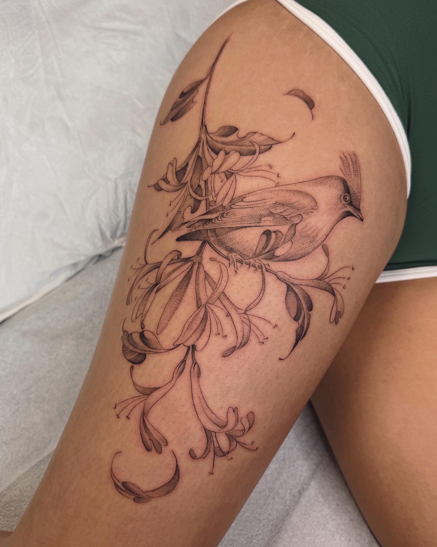 Bird and flowers realism tattoo on the thigh by Alyssa . Villela
