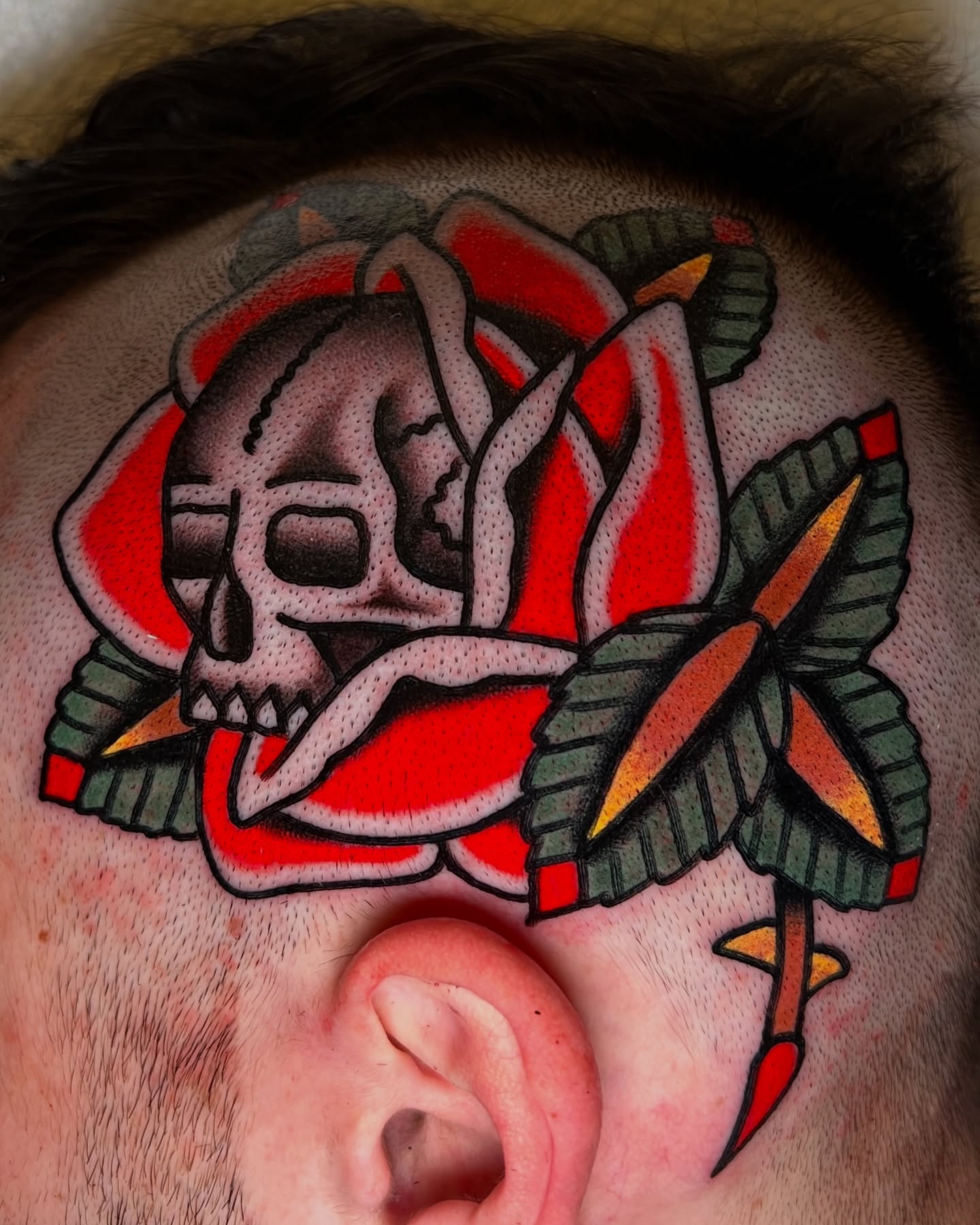 Skull and rose American traditional tattoo on the head by Ian Jett