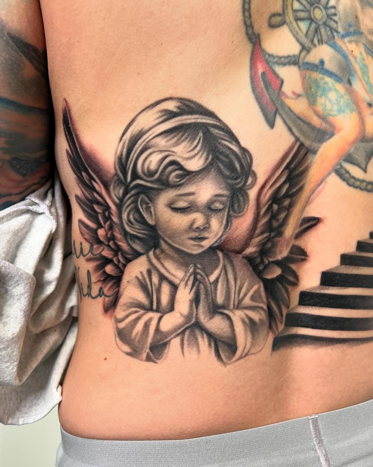 Praying angel black and grey tattoo on the ribs by San Diego Fineline Black & Grey Tattoo Artist
