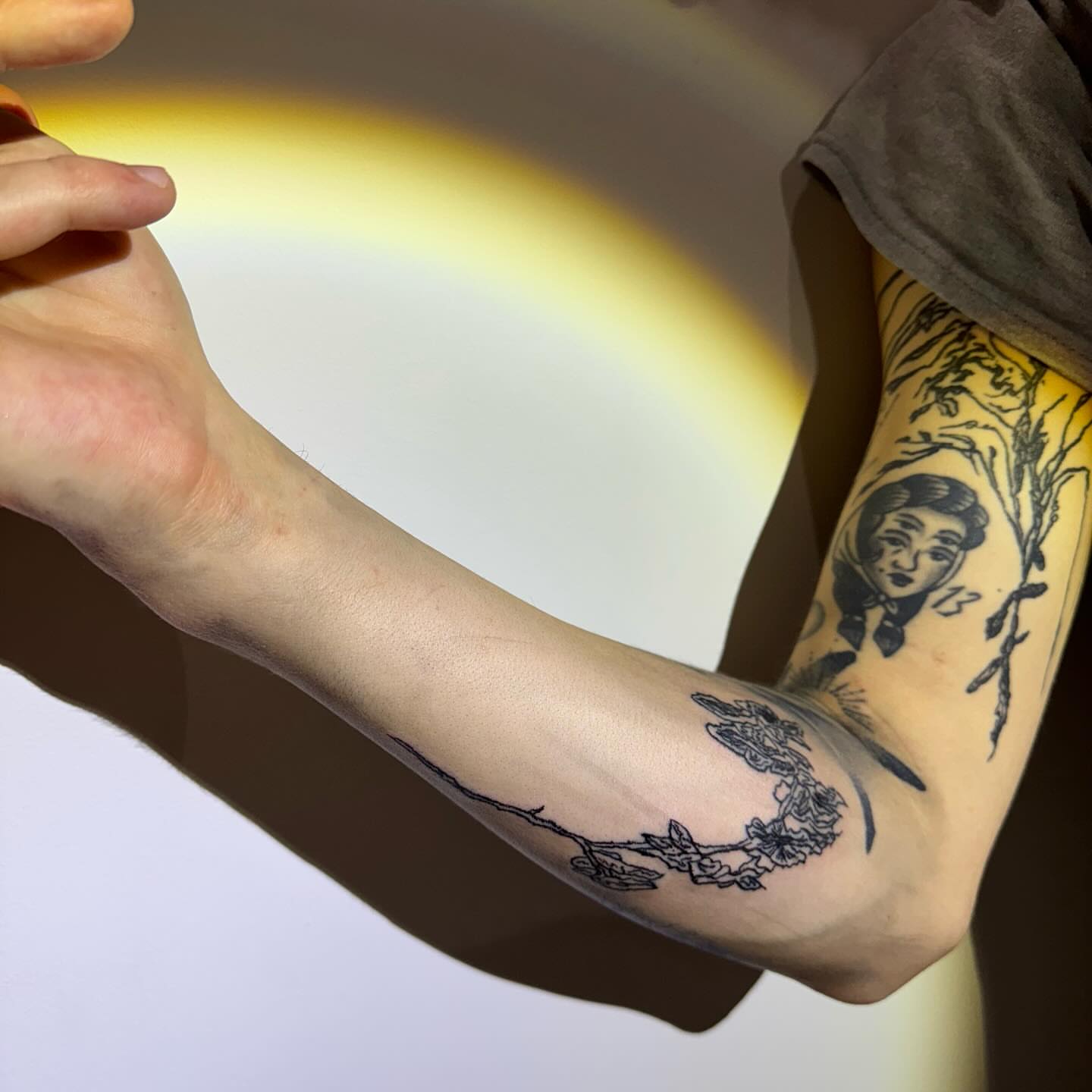 Woman with flowers black and grey tattoo on the forearm by @godsfirmgrip