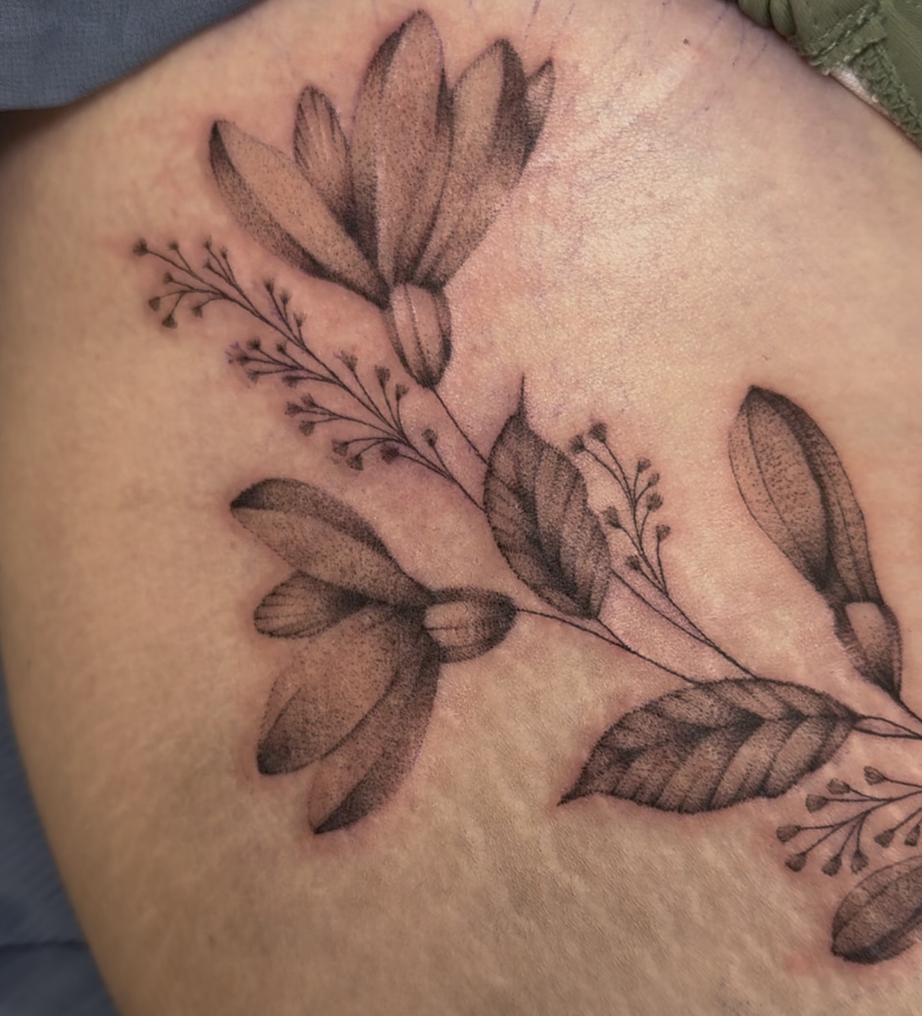 Floral arrangement realism tattoo on the thigh by Tattoo Artist