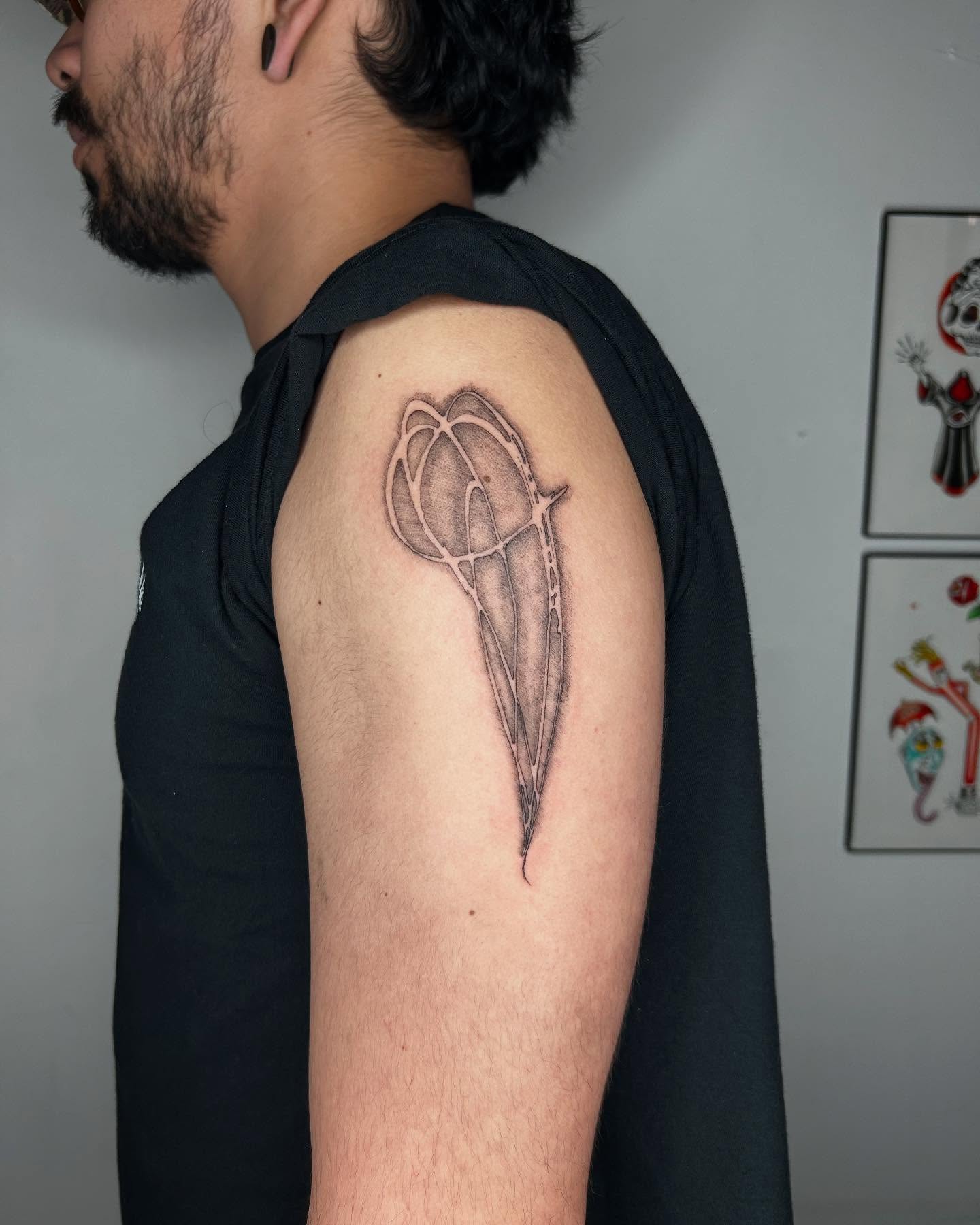 Tulip black and grey tattoo on the upper arm by Jadin Nichols