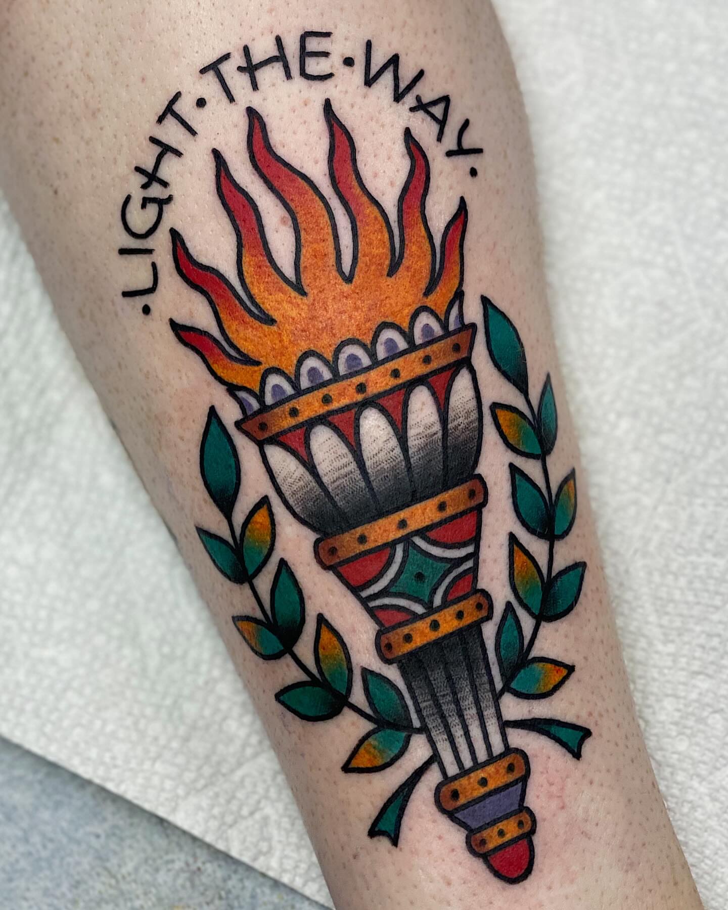 Torch with flame American traditional tattoo on the forearm by Dakota Amato