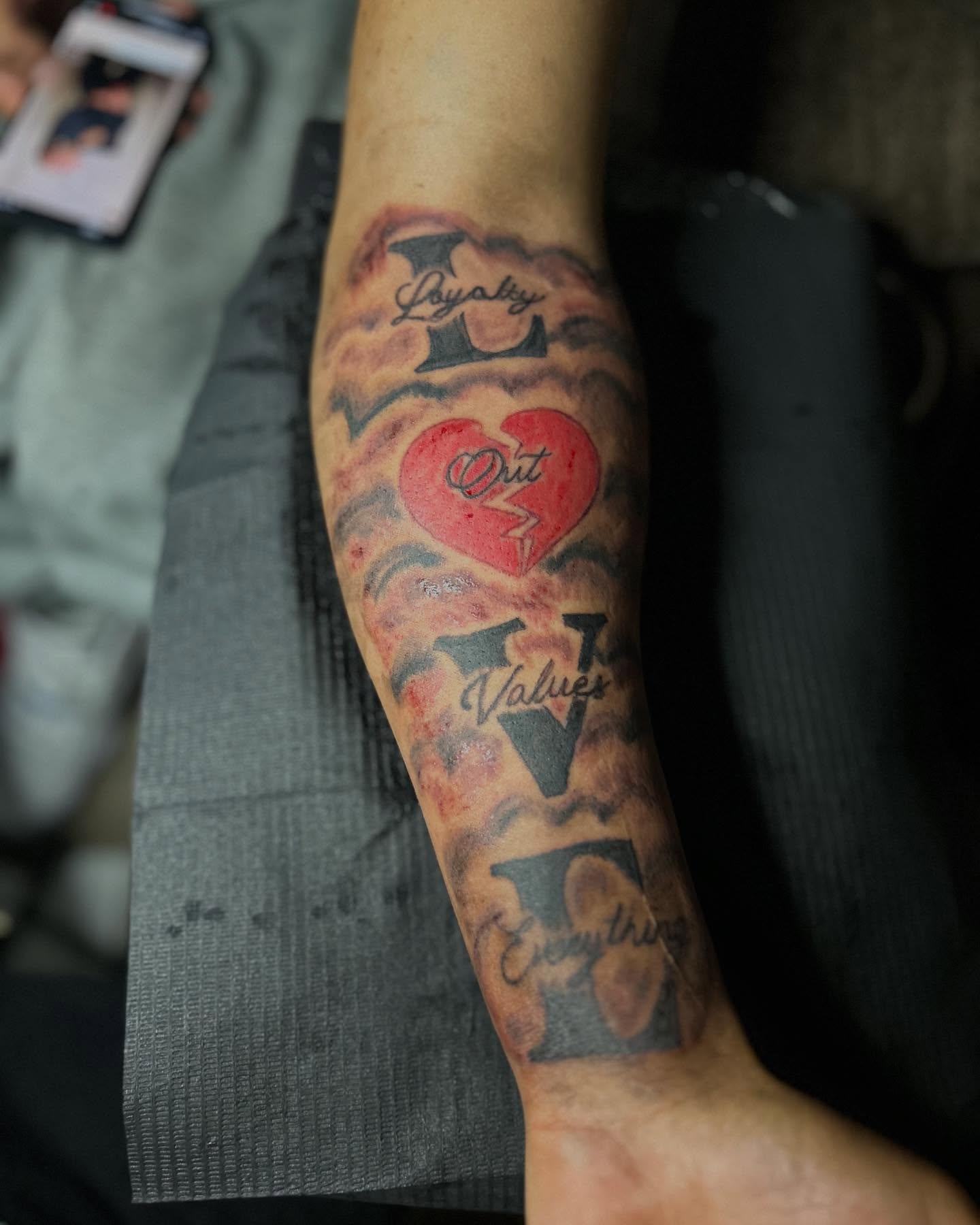 LOVE black and grey tattoo on the forearm by Airika Edwards