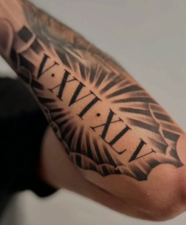 Roman numerals black and grey tattoo on the forearm by Christopher Heffley