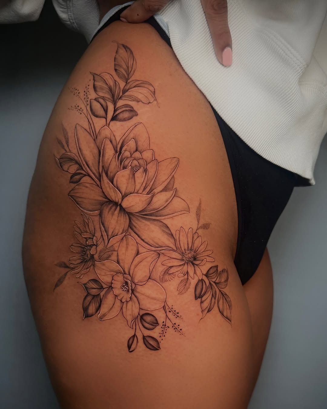Floral arrangement fine line tattoo on the thigh by Nyc Tattoo Manhattan