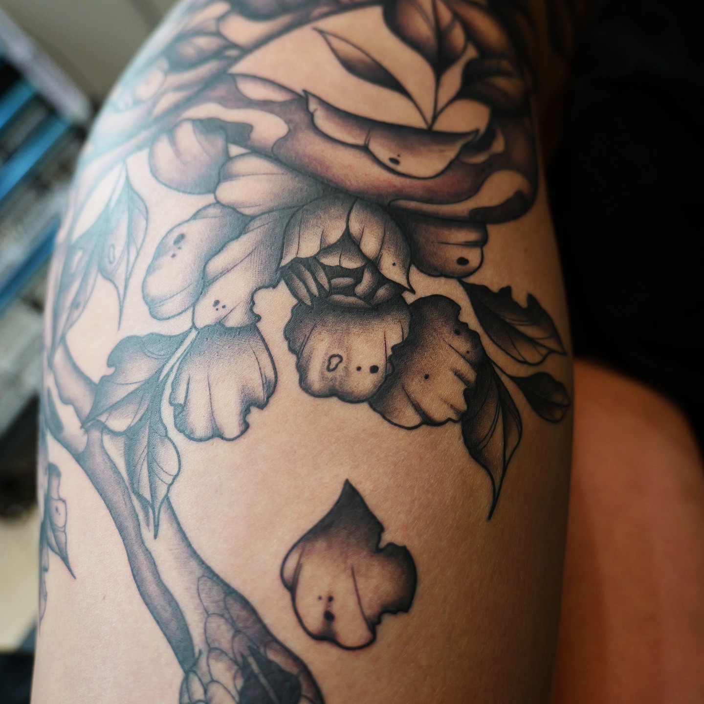 Floral arrangement black and grey tattoo on the upper arm by bobby allensworth