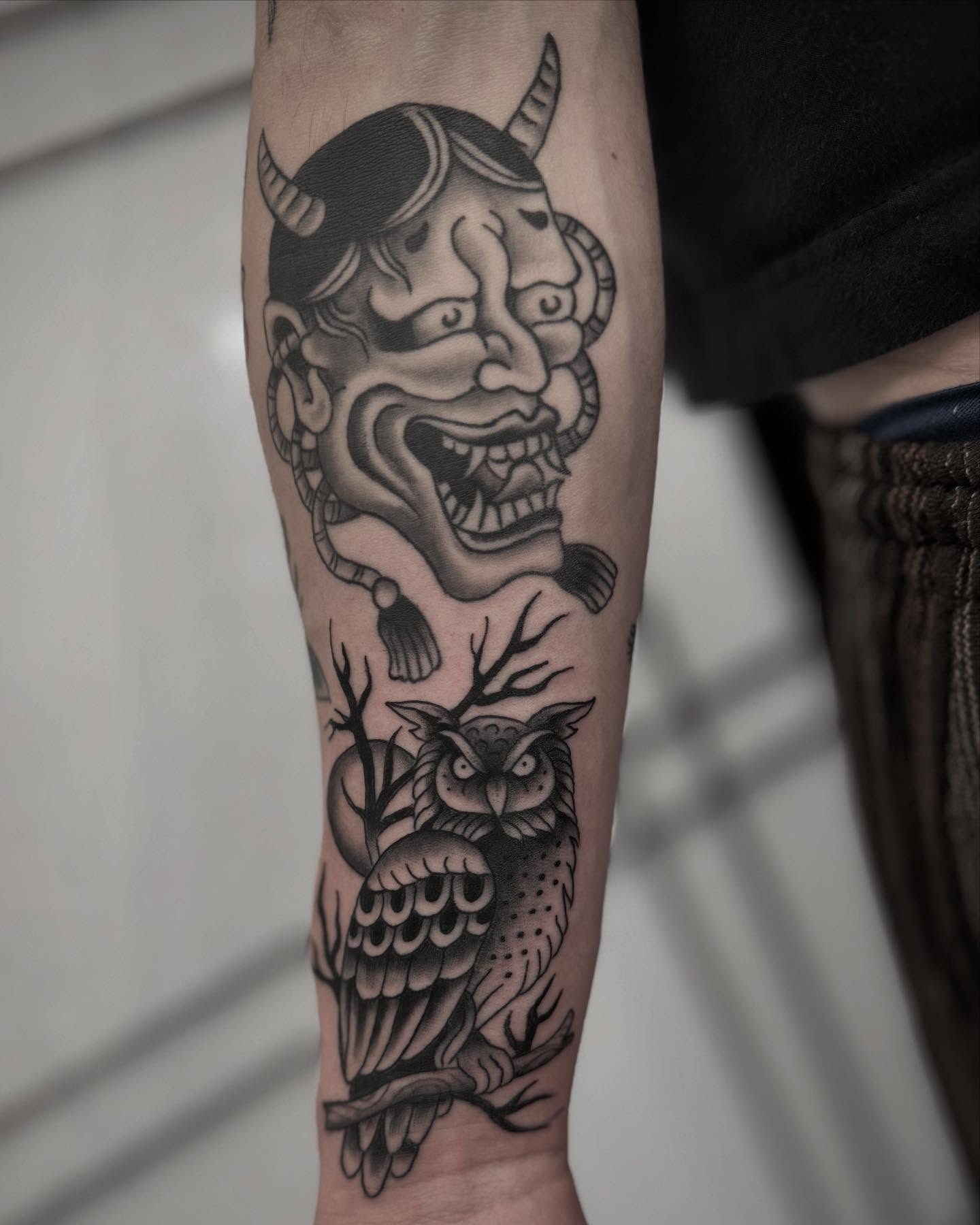 Demon mask and owl American traditional tattoo on the forearm by Micah Norman, San Francisco, California