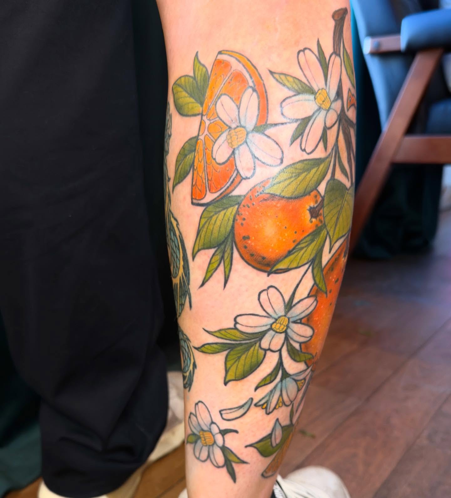 Orange and flowers American traditional tattoo on the forearm by Jessica Haug