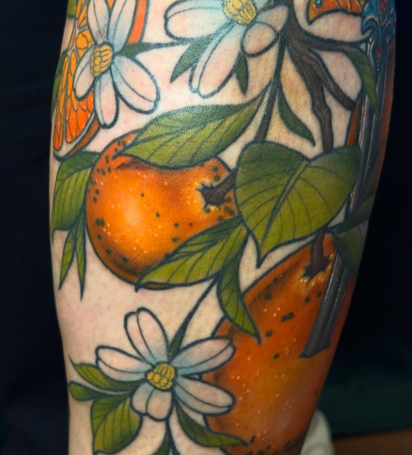 Orange and flowers American traditional tattoo on the forearm by Jessica Haug