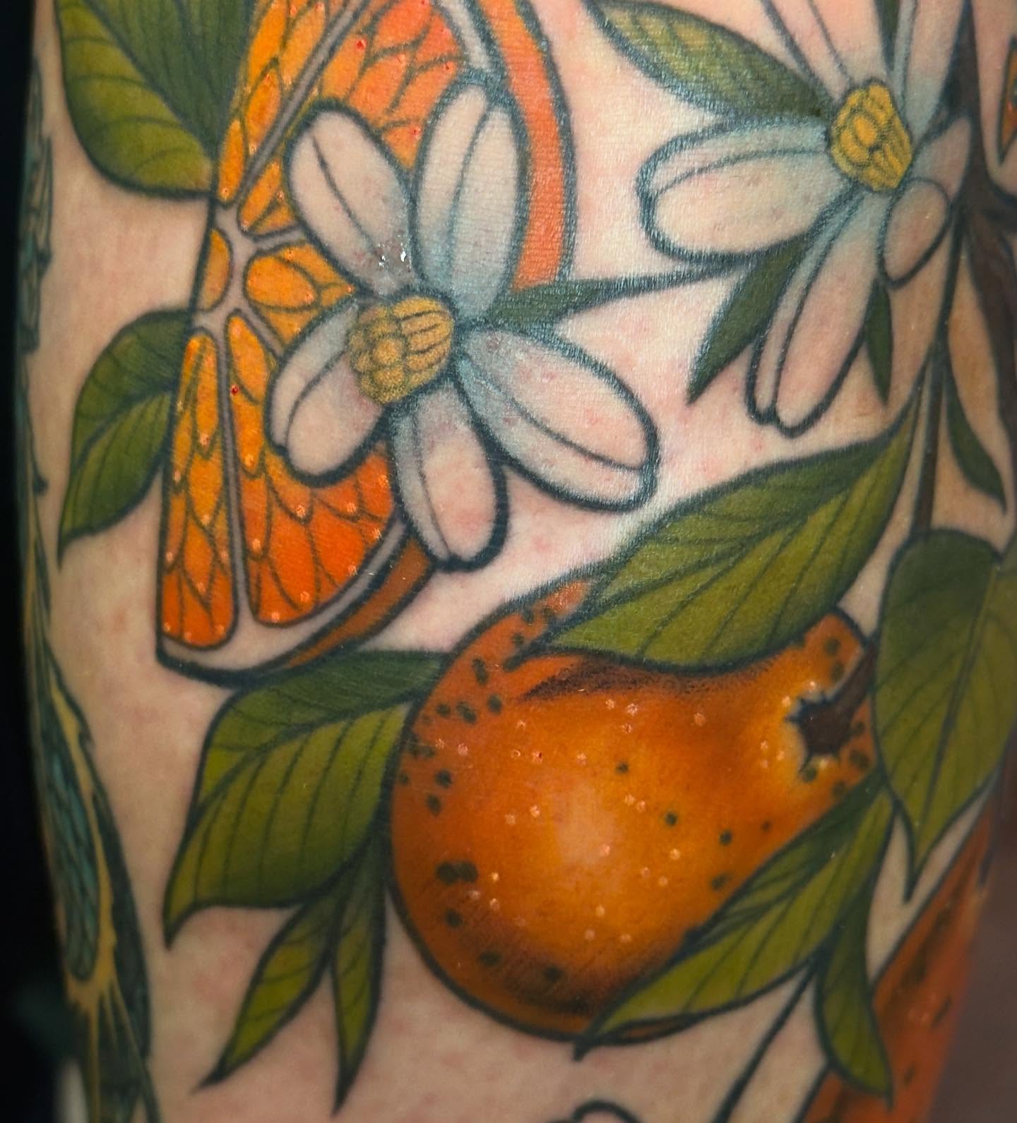 Orange and flowers American traditional tattoo on the forearm by Jessica Haug