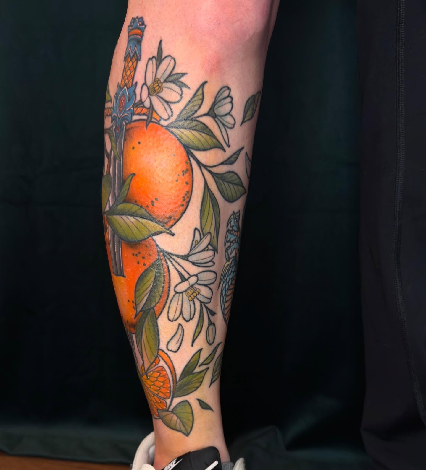Orange and flowers American traditional tattoo on the forearm by Jessica Haug