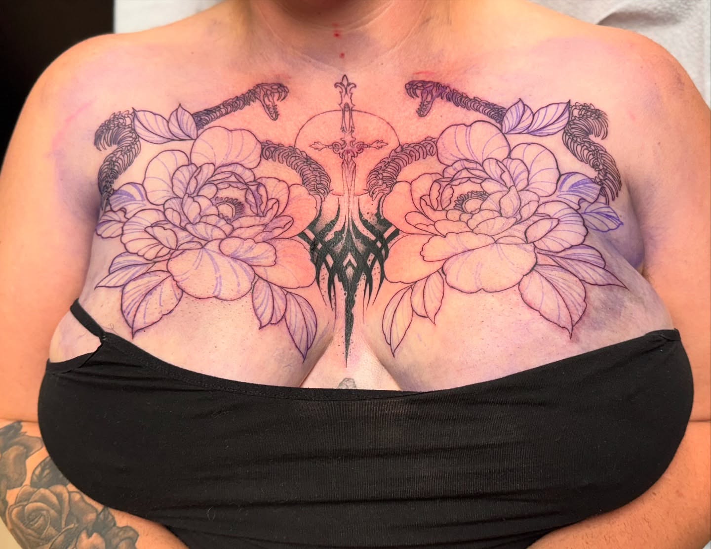 Floral and sword neo-traditional tattoo on the chest by Tattoo Artist