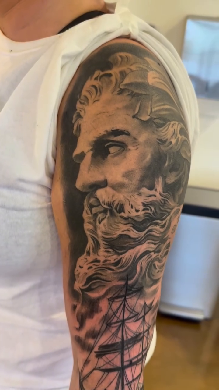 Bust of Zeus with a ship realism tattoo by Mason Williams
