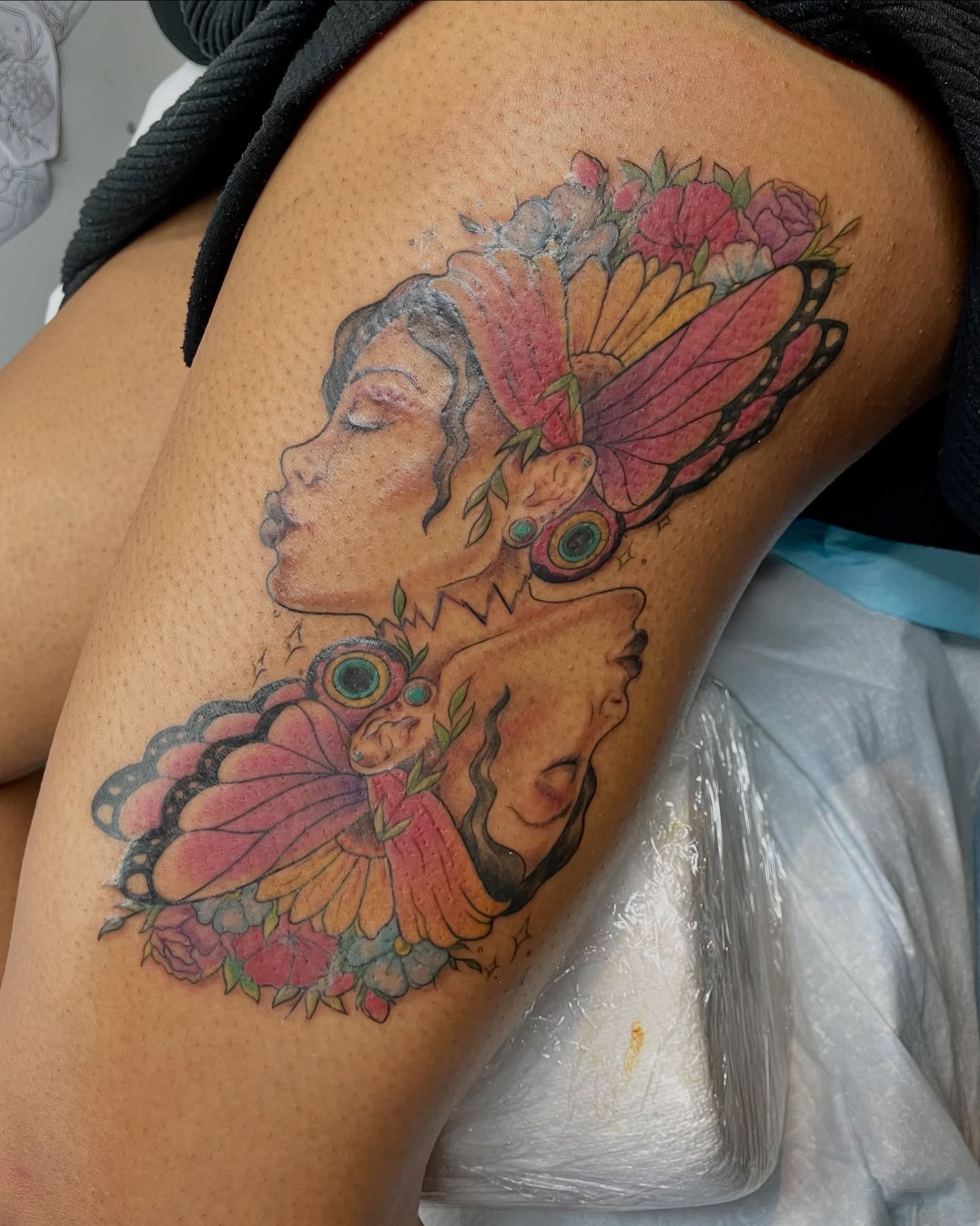 Woman with butterfly wings new school tattoo on the thigh by Christin Baumgart