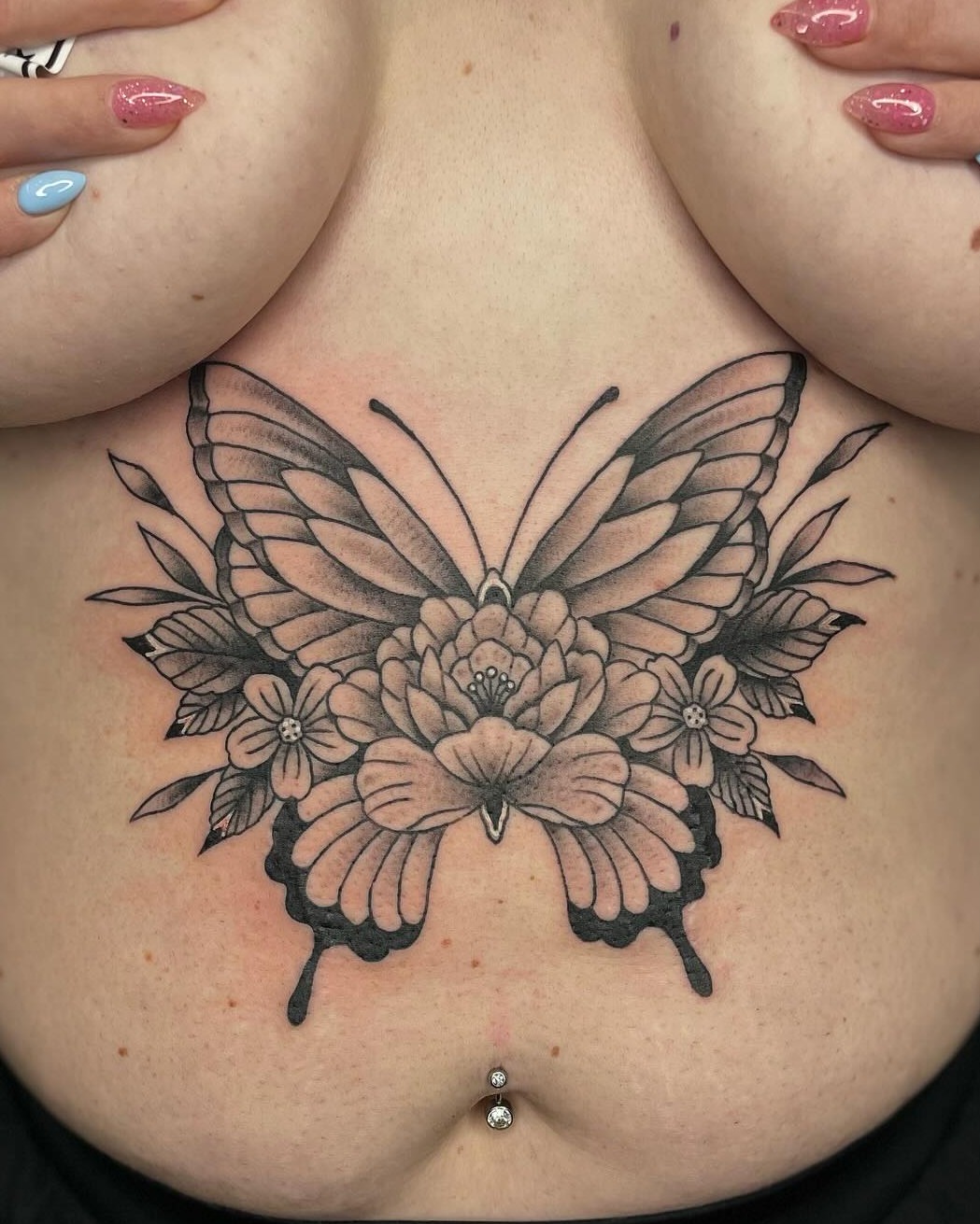 Butterfly and flowers black and grey tattoo on the chest by Dave Kruseman