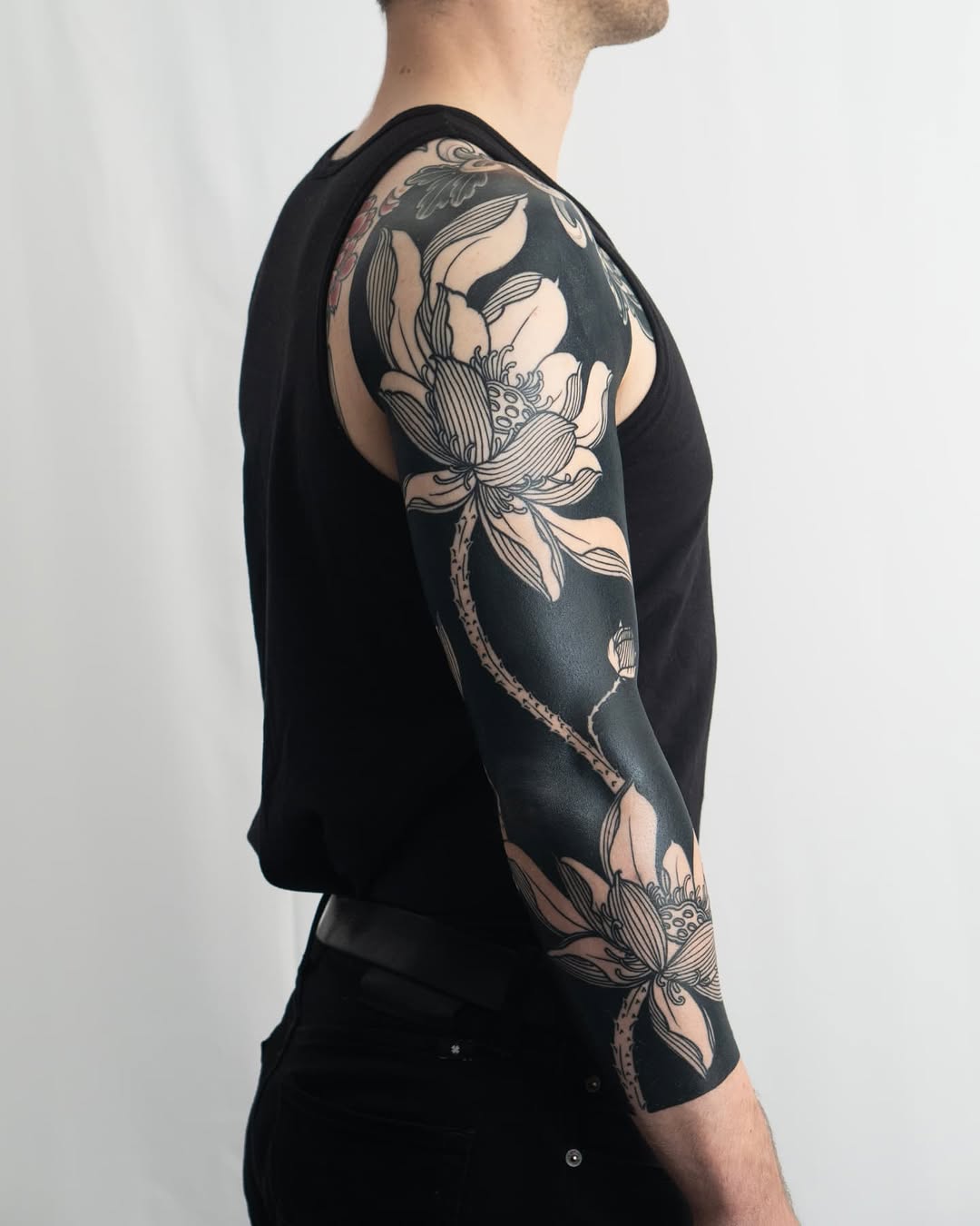 Lotus flower sleeve Japanese tattoo on the upper arm by Kevin Ligabue