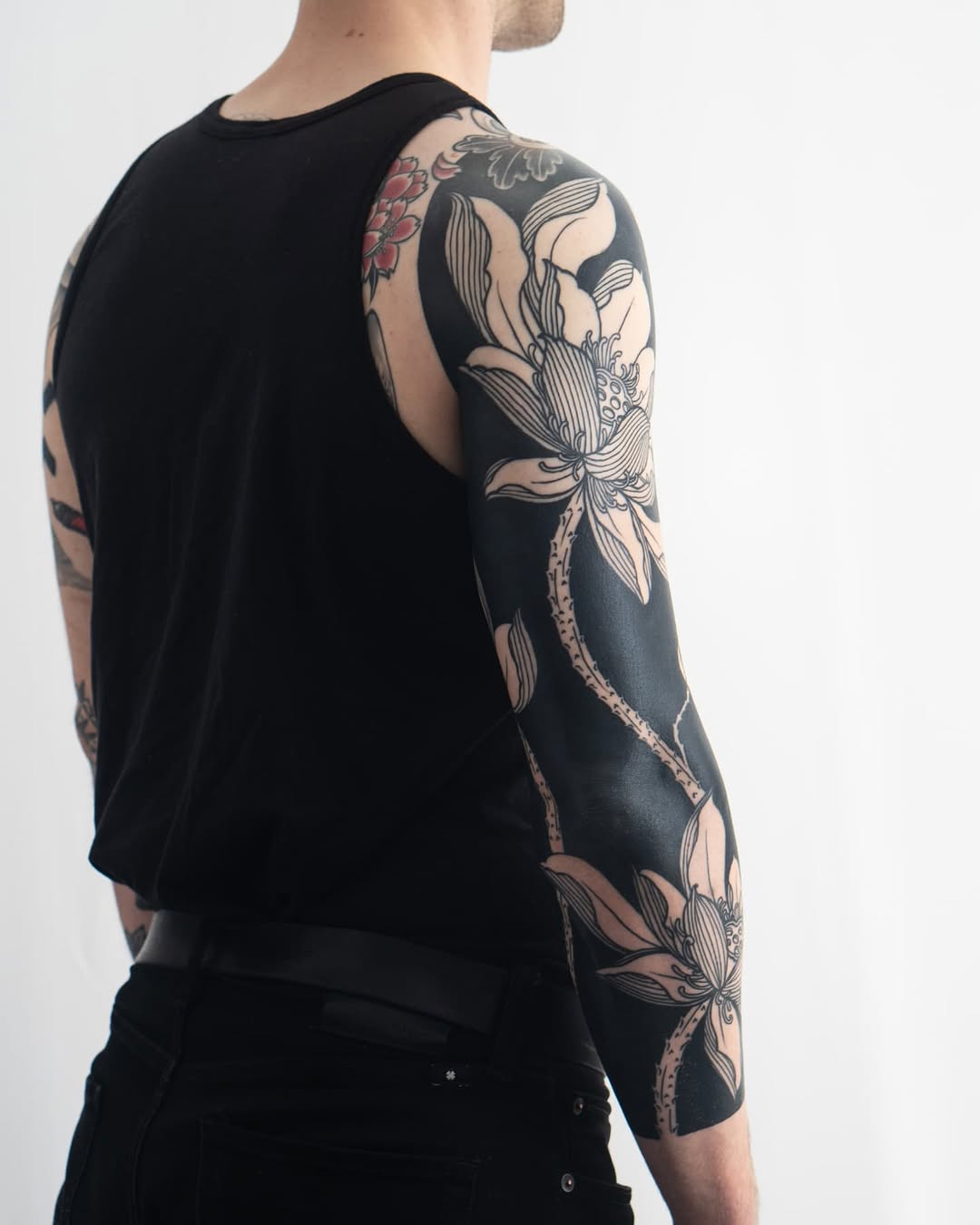 Lotus flowers Japanese tattoo on the upper arm by Kevin Ligabue