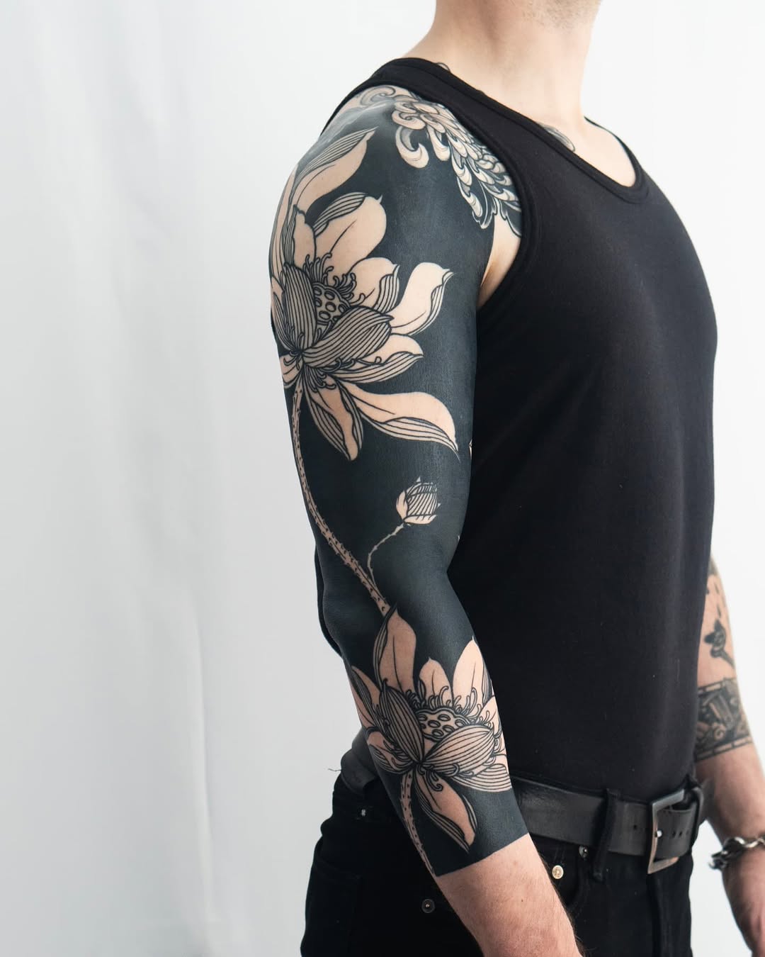 Lotus flowers Japanese tattoo on the upper arm by Kevin Ligabue