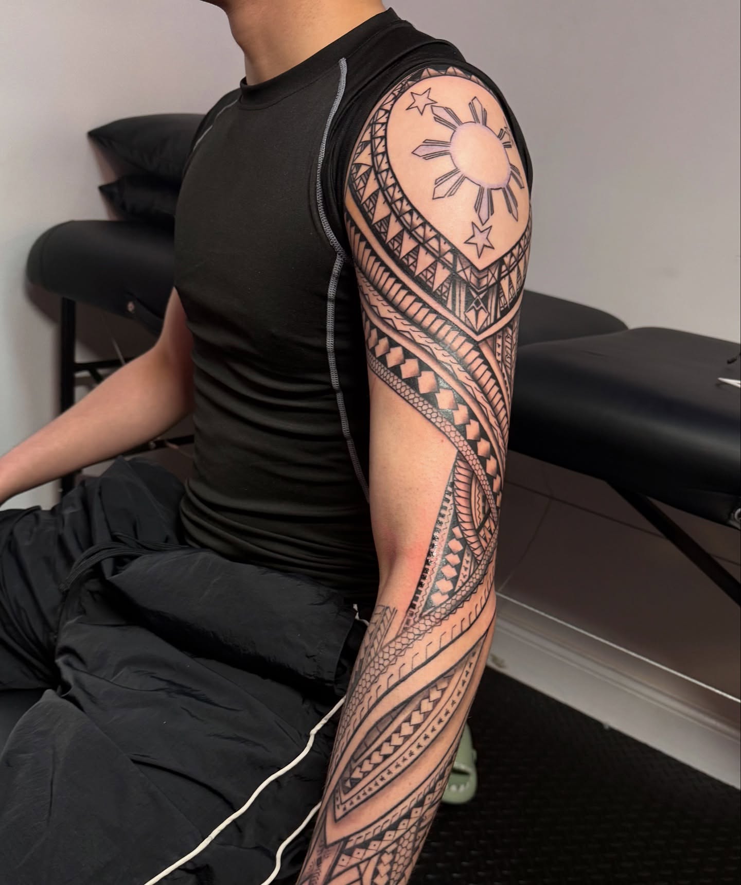 Tribal sun and stars tribal tattoo on the upper arm by Ivy lee