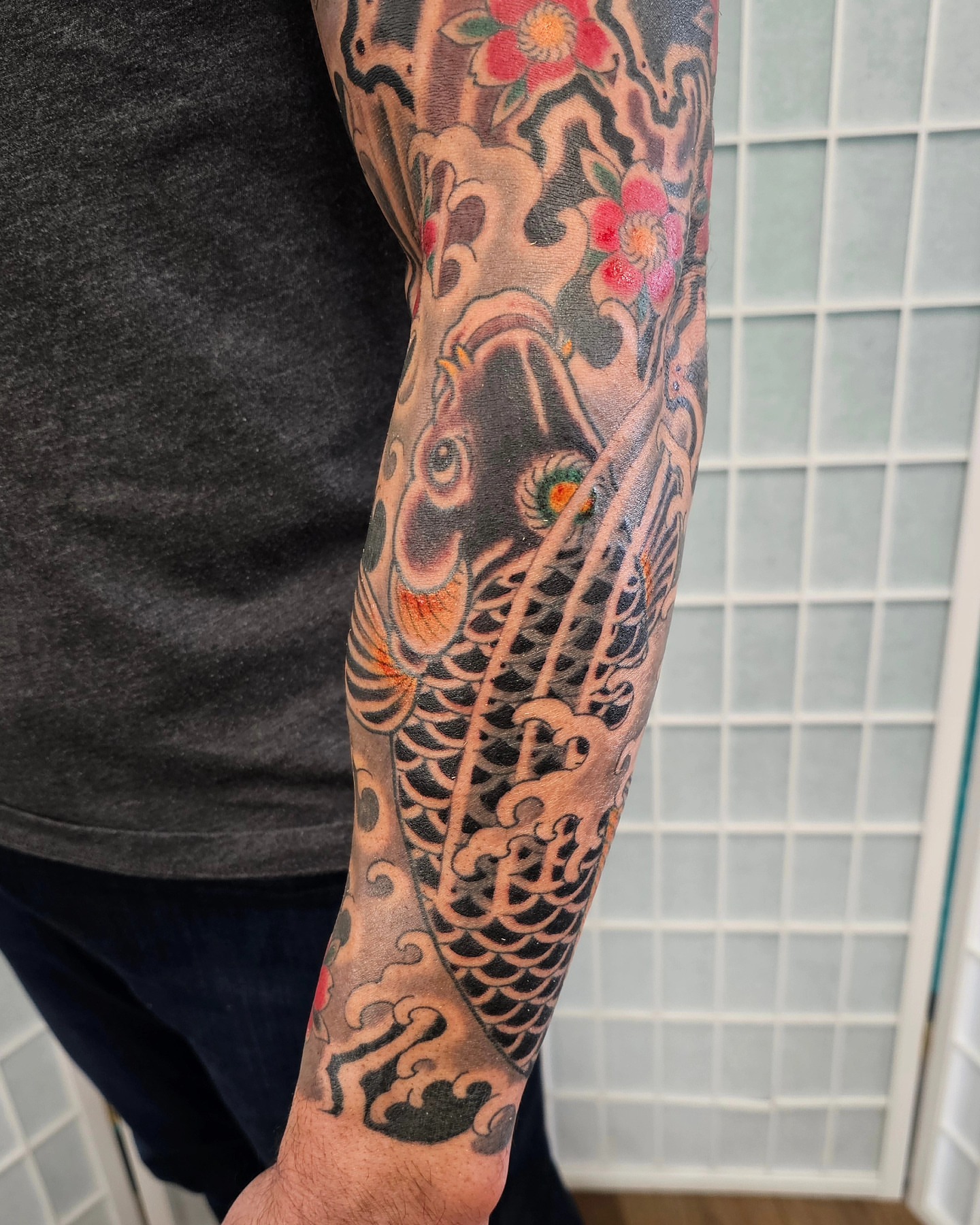 Koi fish and flowers japanese irezumi tattoo on the forearm by Avelourd Legaspi