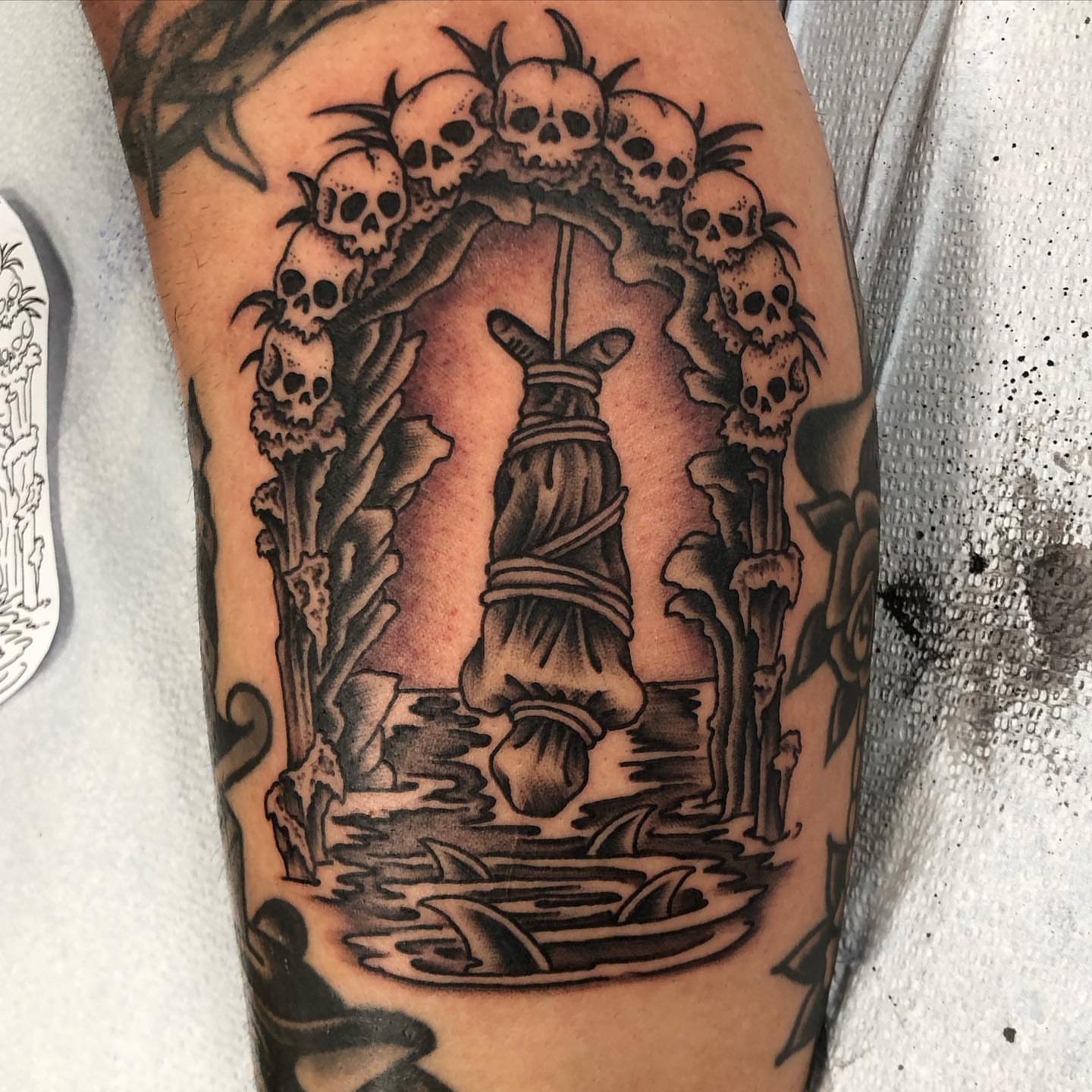 Hanged figure dark realism tattoo on the forearm by Matt Klass