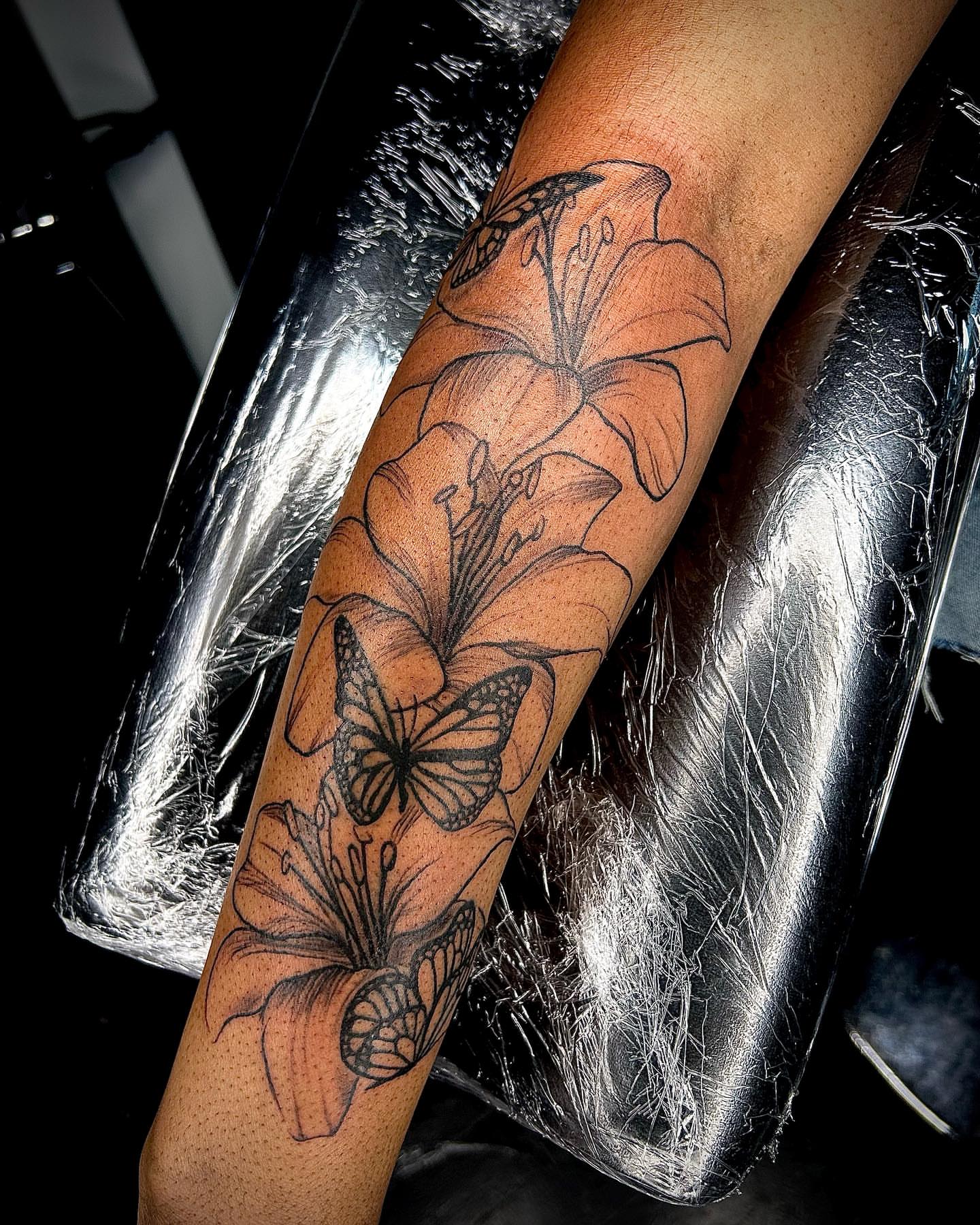 Lilies and butterflies black and grey tattoo on the forearm by Cleveland Tattoo Artist, Cleveland, Ohio